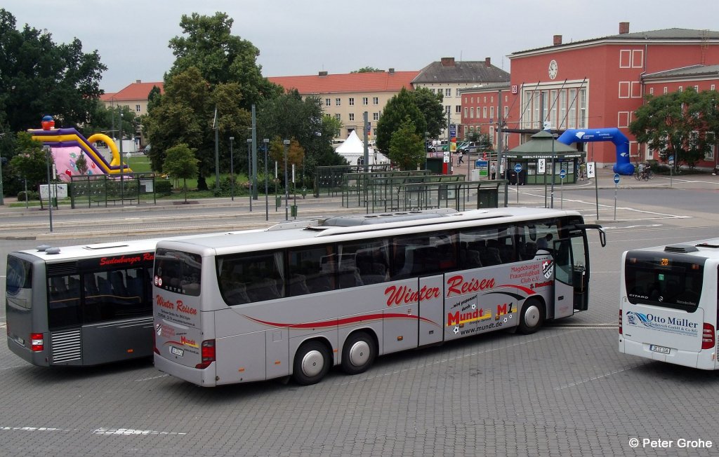 nochmals der Setra S 416 GT-HD von Winter - Reisen aus Egeln mit Werbung fr Magdeburger Frauenfuball Club e.V. und Mundt Energie-Service, fotografiert in Dessau mit Hauptbahnhof im Hintergrund am 07.07.2012