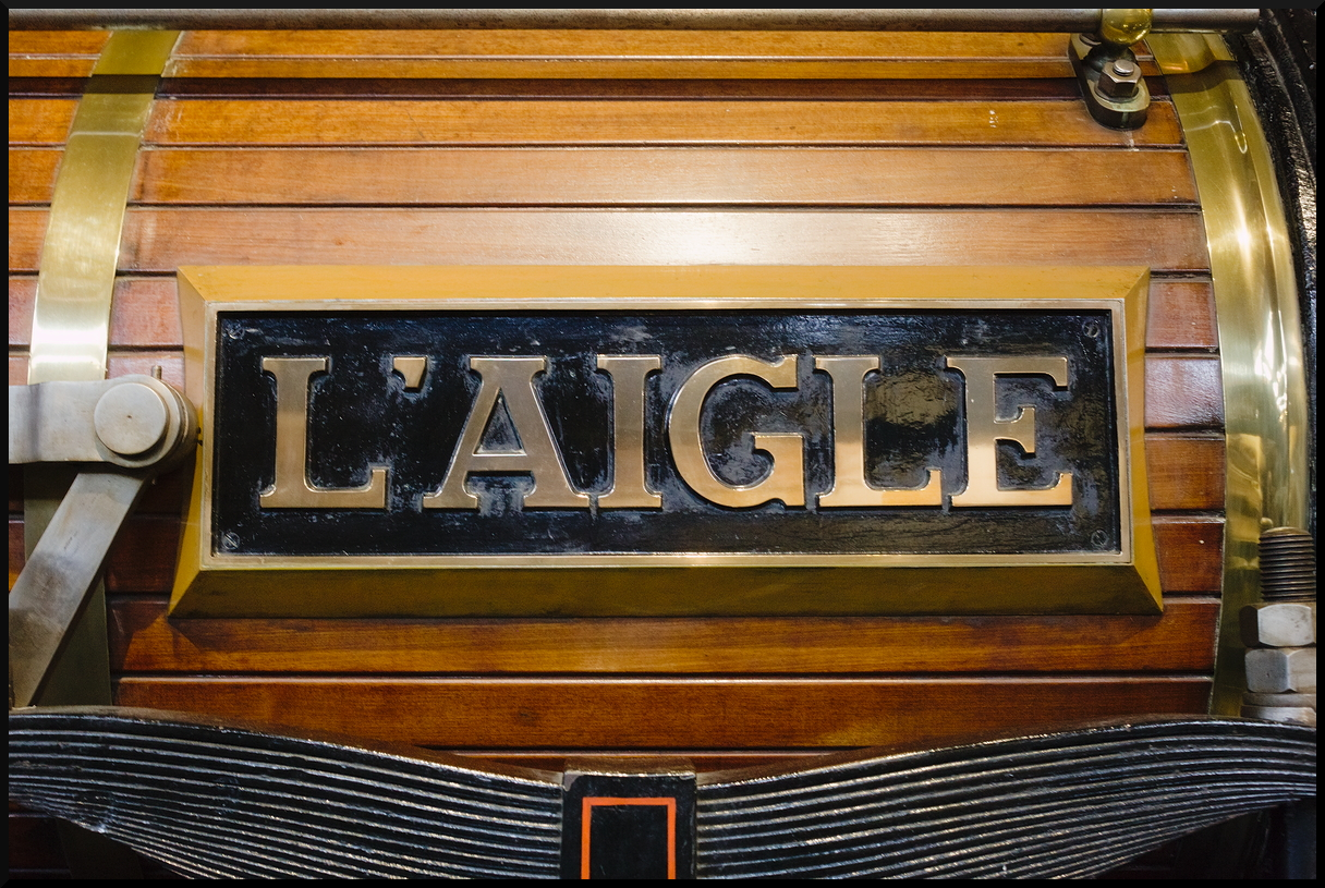 Namensschild  L'Aigle  der 111-Stephenson No. 6 aus dem Jahr 1846. Das feine Detail befindet sich auf der Holzverkleidung des Kessel der Dampflok, die heute im Eisenbahnmuseum Cite du Train in Mulhouse steht. Bei einem Besuch am 10.11.2023 wurde das Schild fotografiert.