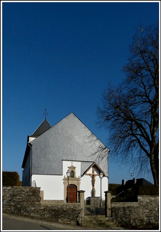 Auf einer Anhhe in Holler, einem der ltesten Drfer Luxemburgs, steht einer der beeindruckensten und schnsten Kirchen des Landes. Sie ist im romanisch-gotischen Stil des Mittelalters erbaut und erinnert durch ihren schweren, quadratischen Turm aus dem 12. Jahrhundert an eine Wehrkirche. Heute steht die Kirche von Holler unter Denkmalschutz. 14.03.2012. (Jeanny)