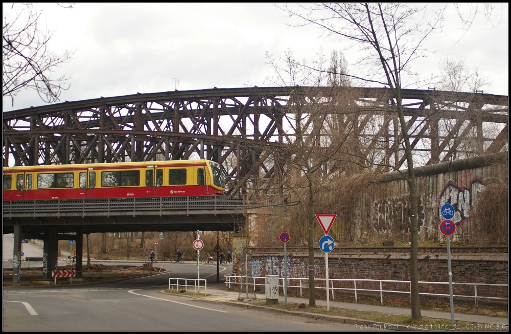 Blick auf die Liesenstraenbrcke mit vorbeifahrender S-Bahn und einem Mauerstck in Berlin Humboldthain