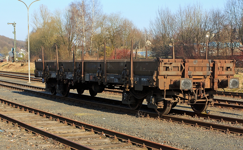 Drehgestell-Flachwagen mit Seitenborden - Remms 665 (394 8 557) der DB, abgestellt am 20.03.2012 in Herdorf. Zwischen 1976 und 1978 wurden fr die DB 660 Remms 665 nach UIC-Standard gebaut. Die Wagen haben abklappbare Aluminium-Seitenborde, die durch 10 Fallrungen gesichert werden. Auf Feststellbremsen und die selbstttige Lastabbremsung wurde bei den Remms 665 verzichtet. Im Wagenboden befinden sich 12 absenkbare Verzurreinrichtungen. 