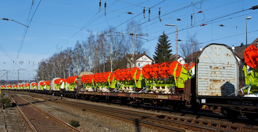 Ein Langer Gterzug fhrt am 11.02.2012 durch Kreuztal Richtung Hagen, mit: Transwaggon Flachwageneinheiten mit geradem Fuboden und festen Stirnwnden beladen mit Schneidwerken der Fa. Claas fr Mhdrescher
Rechts ein Typ Laas (eigendlich ein Rungenwagen, der Rest ist vom Typ Laalps.