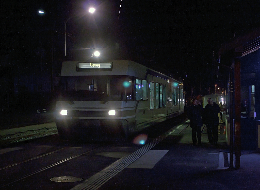 Ein Schienen-Wohnwagen bei Nacht: Am 25.02.2012 im Bahnhof Blonay der meterspurigen Triebwagen Be 2/6 - 7003 (Stadler Elektrischer Niederflur-Doppelgelenk-Leichttriebwagen Typ GTW 2/6) der MVR (Transports Montreux–Vevey–Riviera) ex CEV (Chemins de fer lectriques Veveysans), steht zur Abfahrt nach Vevey bereit.