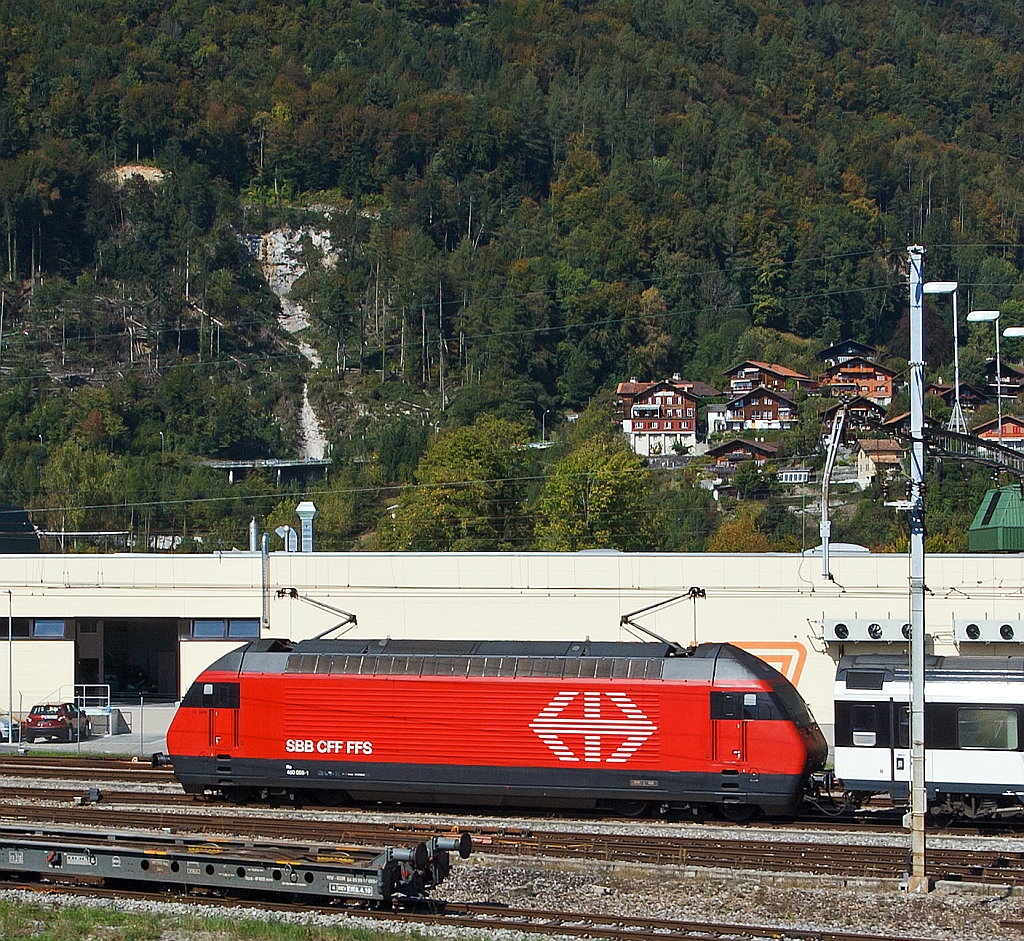 Eine SBB Re 460 mit IC, abgestellt am 30.09.2011 in Interlaken-Ost, aufgenommen aus fahrendem Zug.