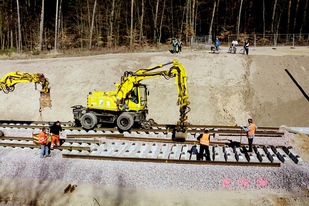 Historisches Bild von der ICE Neubaustrecke Kln Frankfurt whrend der Bauphase. Gleisverlegearbeiten mit einem Zweiwegebagger am Streckengleis vom Flughafenbahnhof Kln/Bonn in Richtung Kln Hbf kurz hinter dem Tunnel, der am Mauspfad endet. Die Aufnahme stammt vom 21.03.2003.