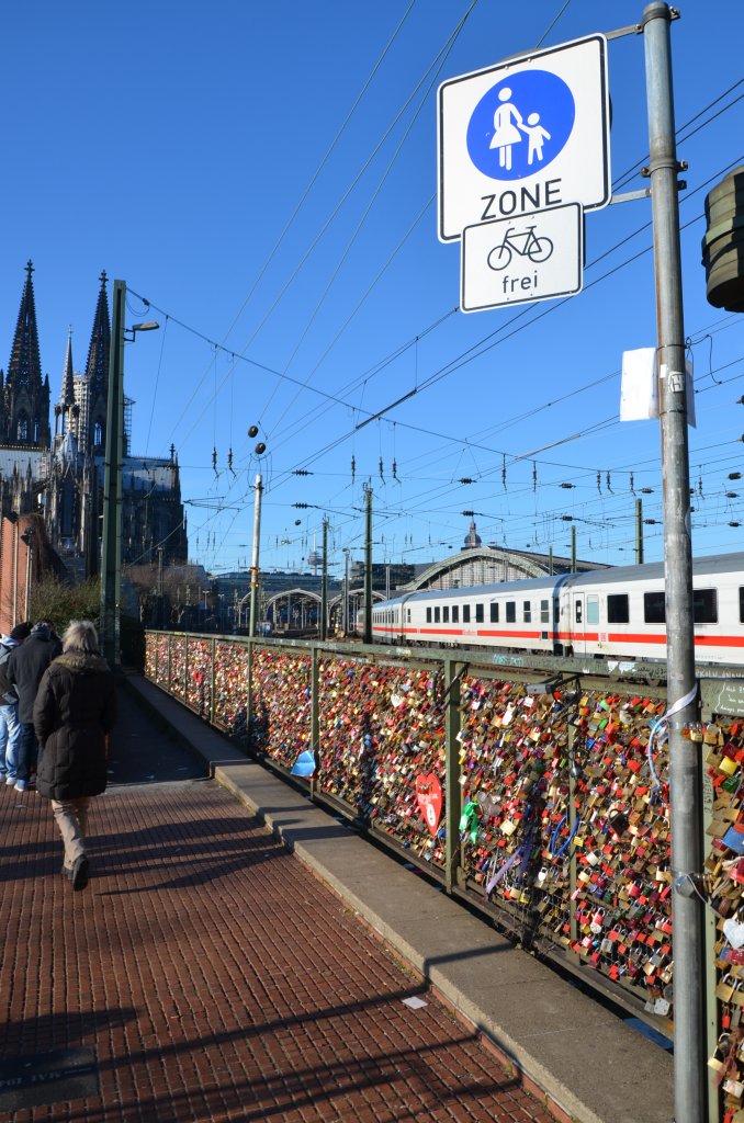 IC bei der Einfahrt in Kln Hbf am 13.01.2013. Im Vordergrund an der westlichen Rampe zur Hohenzollernbrcke sind die Liebesschlsser angebracht. Man schtzt, dass allein an  dieser Brcke 40.000 angebracht sind (http://de.wikipedia.org/wiki/Liebesschloss)