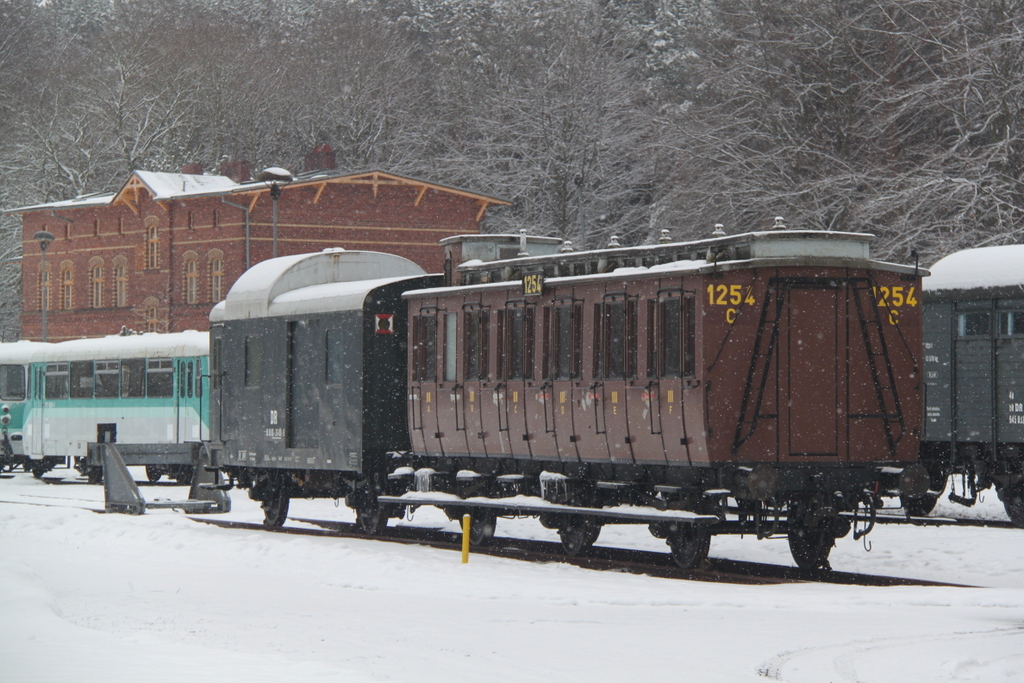 KPEV:dreiachsiger Abteilwagen 3.Klasse mit Bremserhaus abgestellt im Seebad Heringsdorf im Hintergrund stehen die UBB-Ferkel.30.03.2013