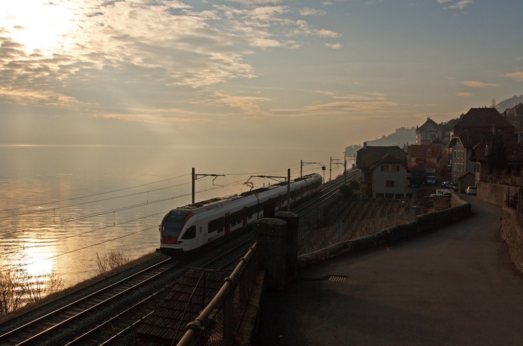 Nachschu: Stadler FLIRT  RABe 523 015 der SBB (RER Vaudois) als S1 (Villeneuve - Montreux -  Vevey - Lausanne -  Yverdon-les-Bains), hier am 2502.2012 bei St. Saphorin. Diese 4-teiligen Garnituren haben die Achsanordnung BO´2´2´2´Bo, eine Leistung von 2.600 kW am Rad, eine Hchstgeschwindigkeit von 160 km/h und haben 162 Sitzpltze.