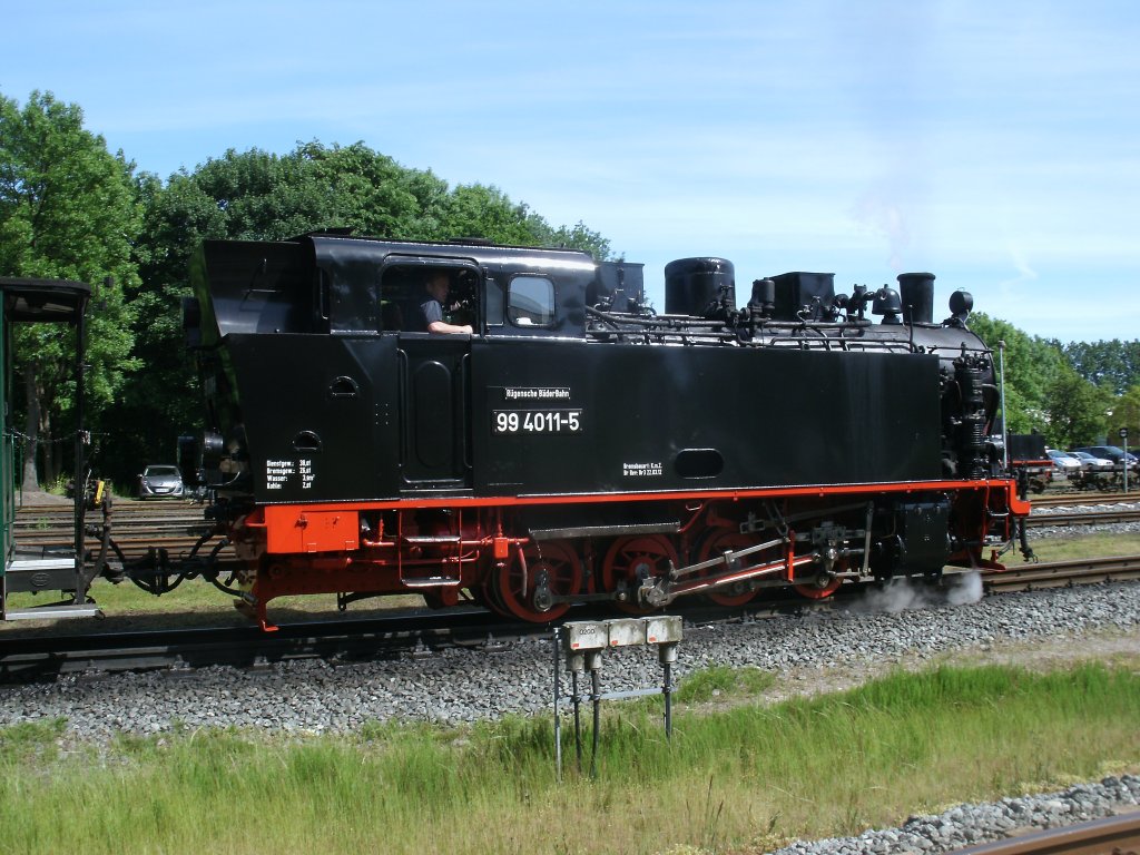 Noch war der Zug f�r 99 4011-5 ein Kinderspiel,denn die Strecke nach Lauterbach Mole ging ins Gef�lle,doch die R�cktour war wegen fehlender,zweiter Lok Schwerstarbeit denn die 99 4011-5 mu�te den gesamten Zug zur�ck nach Putbus schieben.Aufgenommen am 05.Juni 2013 in Putbus.
