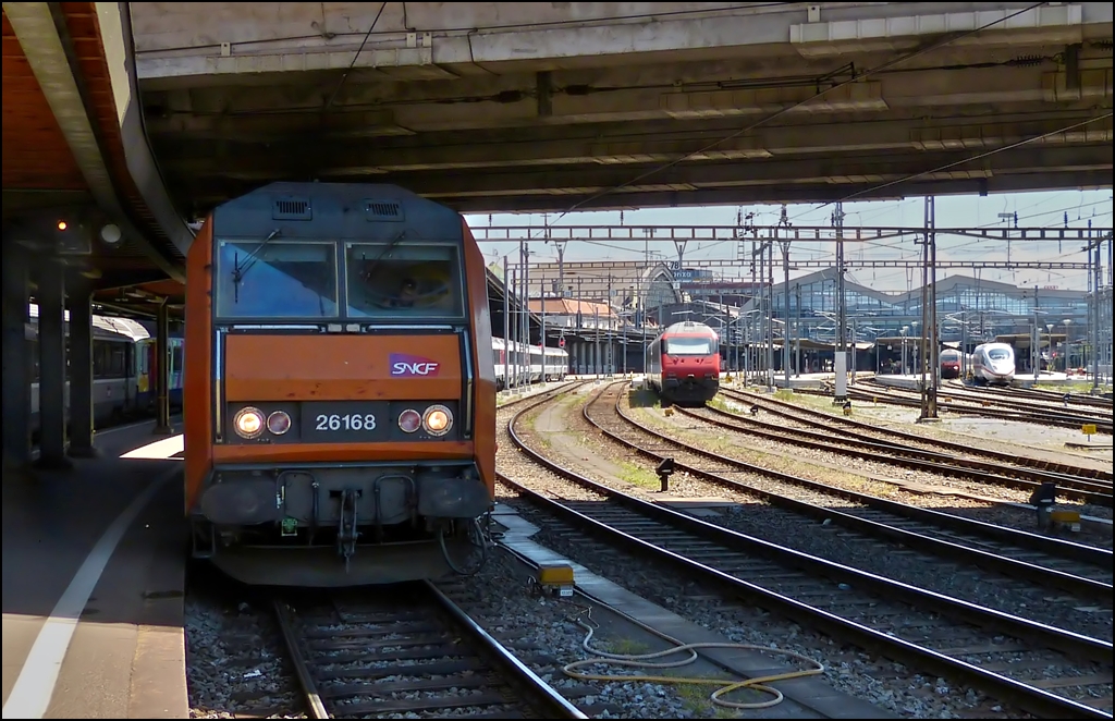 Obwohl das Bild aus Basel SNCF nicht berauschend ist, mchte ich es aus zweierlei Grnden hier zeigen: Rechts im Bild (Basel SBB) ist der ICE zu sehen mit dem Margaretha und Armin am 29.05.2012 nach Hause gefahren sind. Links steht die Sybic BB 26168 mit dem IC (EC) 96  Iris , der uns zurck nach Luxemburg gebracht hat. Entstanden ist dieser Zug aus dem TEE  Iris , der frher Zrich mit Amsterdam verbunden hat und der aus finanziellen Grnden in den 1980er Jahren aufgegeben wurde. Der Name stammt von der hollndischen Nationalblume, der Iris. Die NS waren spter nicht bereit sich an dem neuen Label Eurocity zu beteiligen und deshalb endete der EC Iris in Brssel. Der Stauts Eurocity trgt der Zug heute nur noch in Belgien. In Frankreich und in Luxemburg wurde er zum IC deklassiert, vor allem bedingt durch das Fehlen eines Speisewagens. In der Schweiz fhrt er als Interregio. Wir hoffen jedenfalls, dass es den  Iris  noch lange gibt, da er neben dem  Jean Monet  und dem  Vauban  eine direkte Verbindung zwischen Luxemburg und der Schweiz herstellt. (Hans)   