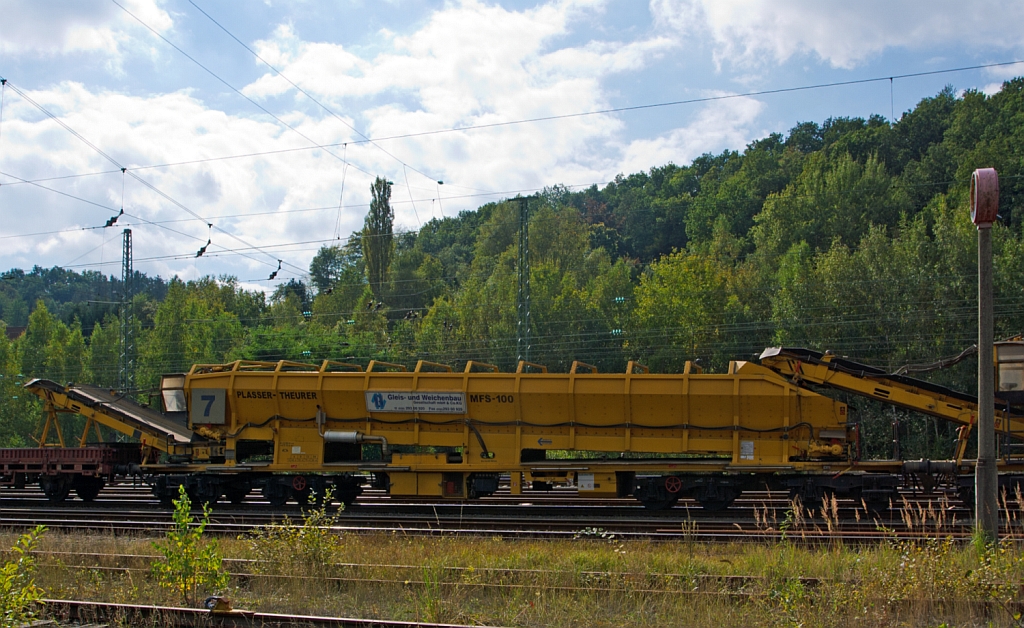 Plasser & Theurer Materialfrder- und Siloeinheit MFS 100 der MGW Gleis- und Weichenbau-GmbH (Berlin) Nr. 7 (Schweres Nebenfahrzeug Nr. 97 19 29 547 57-0),  abgestellt in Betzdorf/Sieg am 22.09.2012.
Die MFS 100 und dienen zum Transport von Schotter, Abraum und Pufferspeicher bei der Bettungsreinigung bzw.Planumsverbesserung. Hauptvorteil ist der kontinuierliche Frder-, Speicher- und Entladevorgang. Eine Zusammenstellung von beliebig vielen MFS-Wagen zu einem Zug mit jeweils gewnschter Speicherkapazittist mglich. Der  Fllvorganges beginnt beim  vordersten Wagen (in Arbeitsrichtung), die folgenden Wagen dienen als Frderstrae.
Eine gleichzeitige Entleerung aller MFS-Wagen durch Ausschwenken der Entladebnder ist mglich, zudem eine dosierte Entladung zum Nachbargleis (Baugleis).
Diese Einheit wurde 2002 unter der Fabriknummer 4062 gebaut.
Technische Daten: Lnge ber Puffer 22.900 mm > Lnge inkl. Frderband 26.550 mm > Achszahl 8 (2 Drehgestelle mit je 4 Achsen) > max. Achslast (beladen) 18t > Eigenmasse 54 t > max. zulssige Zuladung 90 t > Motorleistung 160 kW fr Antrieb der Frderbnder > max. Geschwindigkeit im Zugverband 100 km/h > max. Fassungsvermgen 68 m.