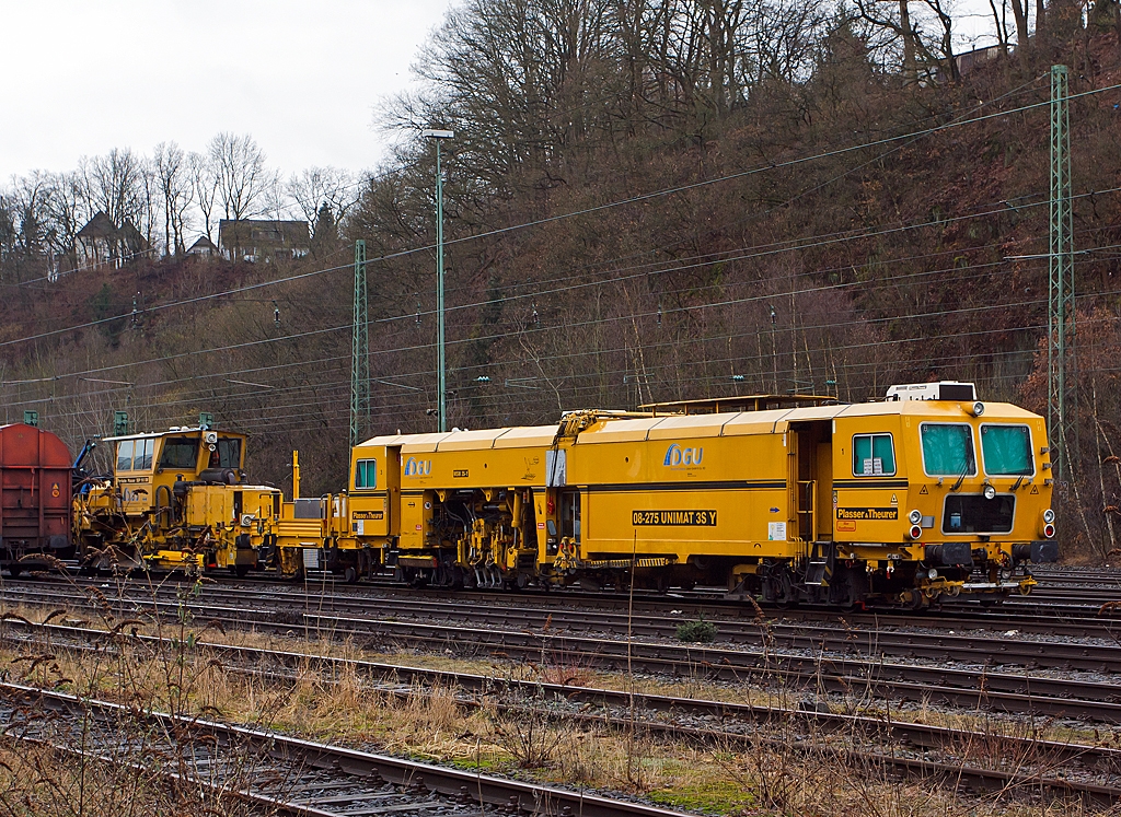 Plasser & Theurer Universalstopfmaschine 08 - 275 Unimat 3S Y (Schweres Nebenfahrzeug Nr. 97 43 41 523 17 - 9) der DGU (Deutsche Gleisbau Union), abgestellt am 09.03.2013 in Betzdorf/Sieg.

Die Maschine ist eine halbautomatisch arbeitende Nivellier-, Hebe-, Richt- und Stopfmaschinen. Sie dient zum Stopfen von Weichen und Gleisen, sie bearbeitet auch Gleise mit Y-Schwellen. Sie wurde 2001 unter der Masch.-Nr. 1172 gebaut.
Technische Daten: 
Eigengewicht: 78 t
Lnge ber Puffer: 28.000 mm
Achsanzahl: 5 
Motorleistung: 348 kW
Fahrgeschwindigkeit mit Eigenantrieb: 100 km/h
zul. Streckenklasse: B2 oder hher
Arbeitsleistung bei Durcharbeitung im Gleis: 400 m/h
Arbeitsleistung bei Durcharbeitung von Weichen: bis zu 8 Weichen in 10 h

Dahinter eine Schotterverteil- und Planiermaschine SSP 110 SW.