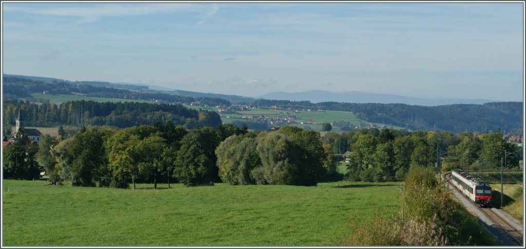 Und ein Blick in die entgegengesetzte Richtung zeigt einen Domino auf dem Weg nach Payerne. Er wird in Krze bei der Kirche ganz links im Bild vorbeifahren.
Bei Palzieux, den 5. Okt. 2012