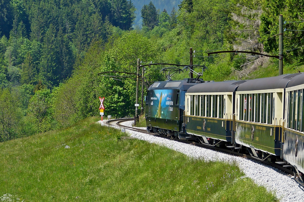 . Am 25.05.2012 standen die alten Fahrleitungsmasten noch zwischen Chteau d'Oex und Rossinire, als die MOB Ge 4/4 8003 den Golden Pass Classic Zug von Zweisimmen nach Montreux zog. (Jeanny)