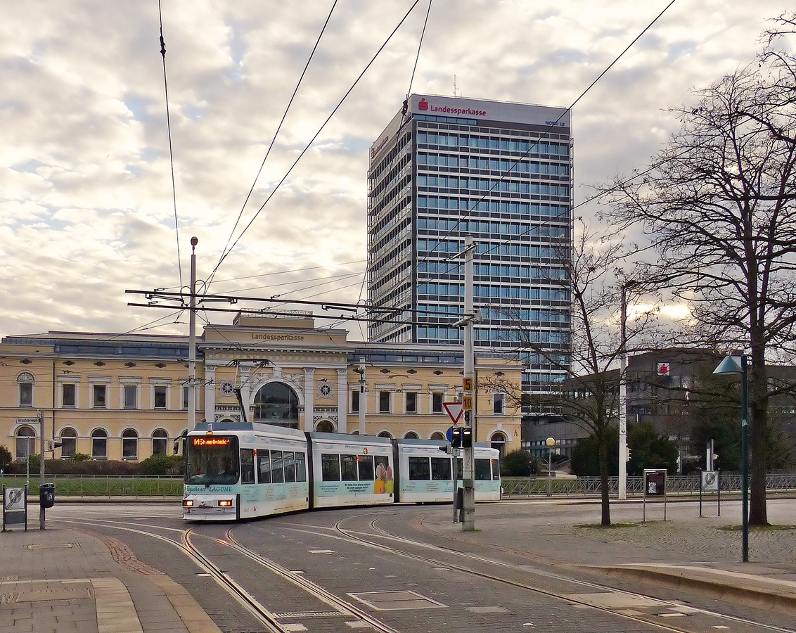 . Am alten Braunschweiger Bahnhof - Der GT6S mit der Nummer 9551 (Bj 1995) der Braunschweiger Straenbahn fhrt am 03.01.2015 auf der Linie M 5 Broitzem - Hauptbahnhof und biegt vom Kalenwall auf den Friedrich-Wilhelm-Platz ein. (Jeanny)

Bei dem Gebude im Hintergrund handelt es sich um den ehemaligen innerstdtischen Braunschweiger Bahnhof, einen Kopfbahnhof von 1845, dessen denkmalgeschtztes Hauptgebude heute als Hauptsitz der Braunschweigischen Landessparkasse dient.

Der einstige Sackbahnhof war ein Ottmer-Bau im gotischen Stil, wurde jedoch in den Jahren 1843/45 im sptklassizistischen Stil neu aufgebaut. Dieser Bau wurde durch Bombardierung 1944 grtenteils zerstrt und 1960 durch einen neuen Durchgangsbahnhof auerhalb der Innenstadt ersetzt. Vom alten Bahnhof ist der Kopfbau erhalten, dessen Fassade von einem Triumphbogenmotiv beherrscht wird. 
