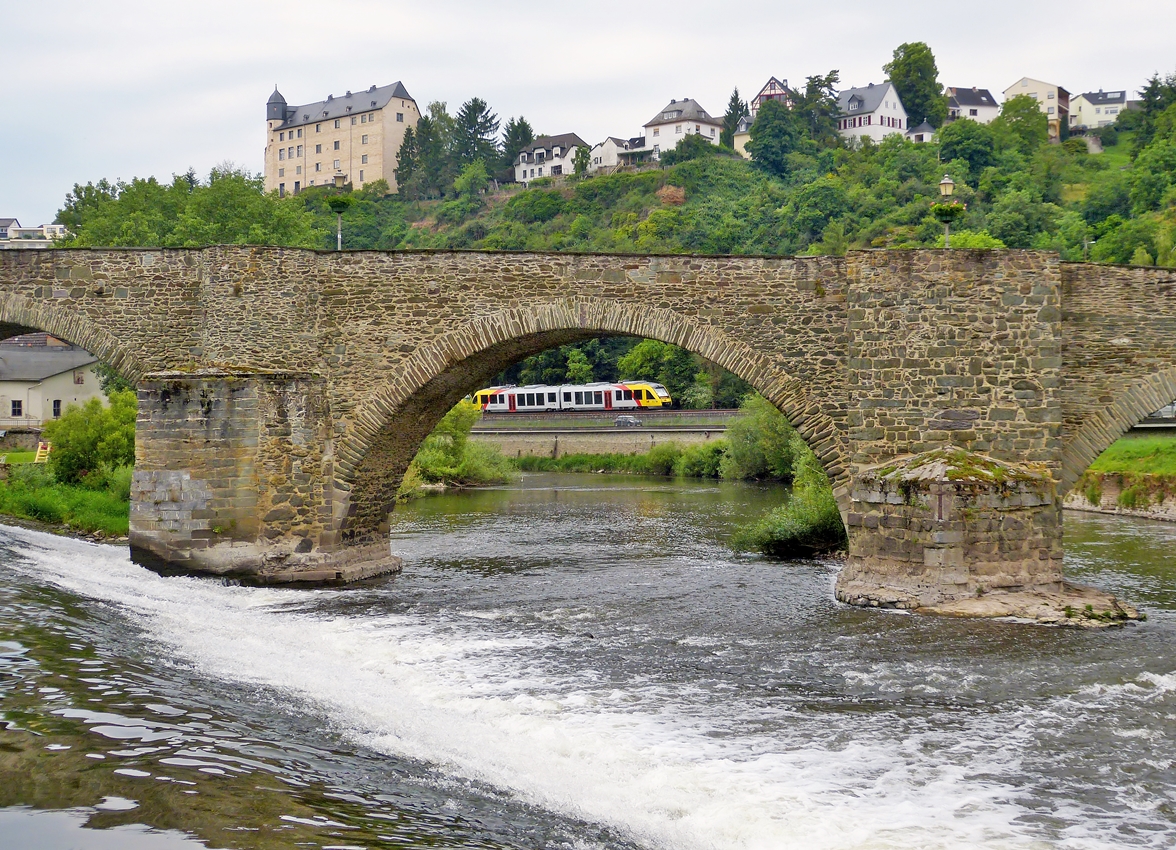 . Der Brckenblick in Runkel - Eine HLB (Hessische Landesbahn) LINT 41 Doppeleinheit hat am 26.05.2014 den Bahnhof Runkel verlassen und fhrt an der Lahn entlang in Richtung Limburg an der Lahn, gesehen durch den Bogen der steinernen Lahnbrcke aus dem 15. Jh in Runkel, whrend oben die Burg Schadeck aus dem 13. Jh zu sehen ist. (Hans)