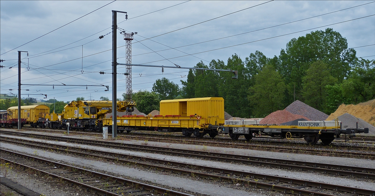 . Der Kirow Gleiskranzug KRC 1200 der Swietelsky Baugeselschaft.mb.H., im Transportmodus, steht am 20.05.2016 im Bahnhofsareal von Ettelbrück.               Der Zug besteht aus: 
1. dem Flachgüterwagen(9100 005-4) vom Typ Us mit der Standartbeladung von 2 Betonblöcken zu je 4,3 t.
2. dem Schutzwagen zu Gleisbaukran KRC 1200, Schweres Nebenfahrzeug (A-RTS 99 81 9377 004-2) auf welchem der Hebearm des Gleiskranes abgestützt ist.
3. Dem Gleisbaukran KIROW KRC 1200, Schweres Nebenfahrzeug (A-RTS 99 81 9119 004-5).
4. Der Gegenlastwagen zu Gleiskran KRC 1200 (99 81 9377 003-4) mit dem  hinteren Gegengewicht des Gleisbaukrans,  und als letztes der Gedeckte Materialwagen  (81 A-RTS 1810 242-9) Typ Gabs, 
5. dem dazugehörende Materialwagen (A-RTS 1810 242-9) vom Typ Gabs.   	          