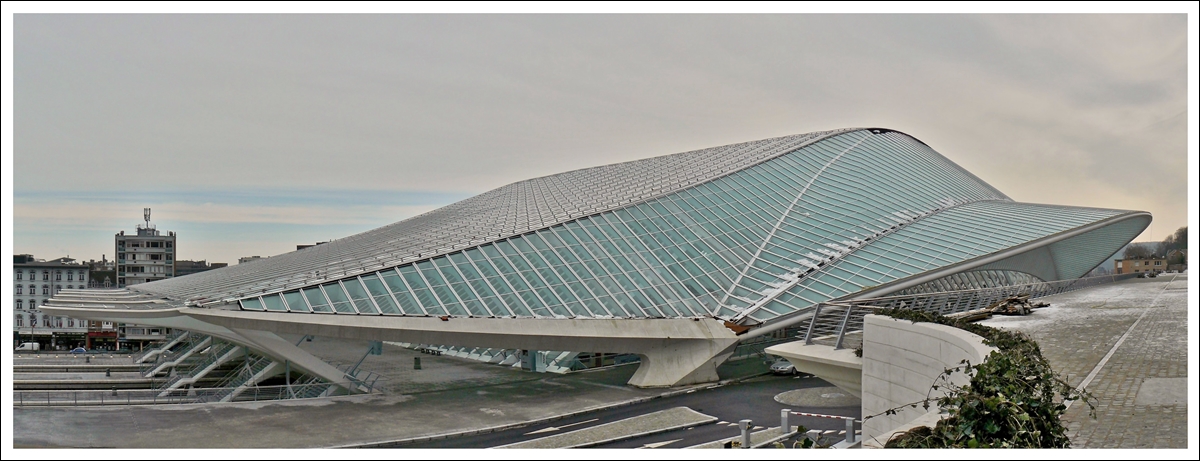 . Wie ein UFO schmiegt sich der Bahnhof Lige Guillemins an die  Colline de Cointe  und passt nicht so recht zu dem umliegenden Bauten des  Quartier des Guillemins  in der frheren Industriestadt Lttich. 16.01.2010 (Hans)

Die beiden Stadtteile  Colline de Cointe  und  Quartier des Guillemins  werden heute durch den neuen Bahnhof verbunden, nachdem sie 170 Jahre durch den alten Bahnhof getrennt waren. Der Name  Guillemins  stammt brigens von einem Kloster aus dem Mittelalter, welches  St Guillaume  gewidmet war und in diesem Stadtteil stand. Die Mnche wurden  Guillemins  genannt und spter wurde dieser Name fr den ganzen Stadtteil bernommen. 

Die Aufnahme besteht aus drei Einzelbildern, die als Panorama zusammengefgt wurden.