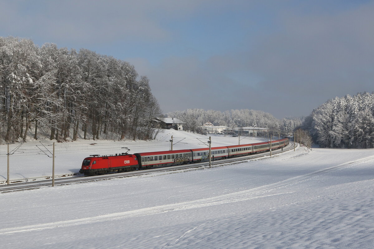1116 087 war mit dem  EC 114  am 13. Januar 2024 bei Axdorf im Chiemgau in Richtung M�nchen unterwegs.