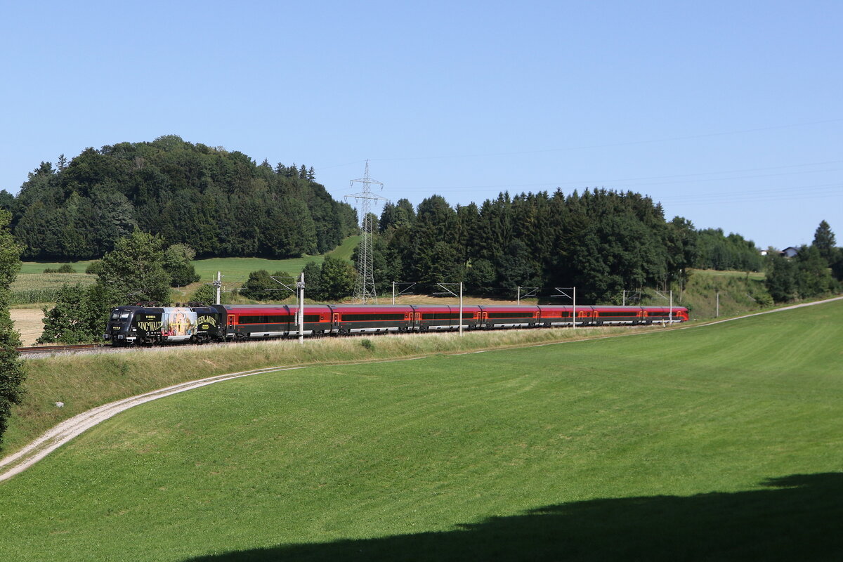 1116 216  200 Jahre Johann Strauss  war am 19. August 2025 bei Vachendorf schiebend an einem  Railjet  in Richtung Salzburg im Einsatz.