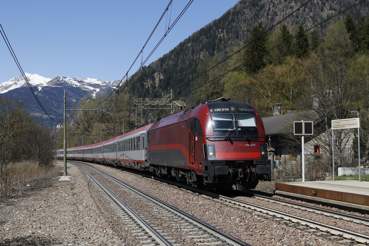 1216 018 mit dem Ec von M�nchen nach Verona. Aufgenommen bei der Einfahrt in den Bahnhof von  Freienfeld/Campo die Trens  in S�dtirol am 8. April 2017.