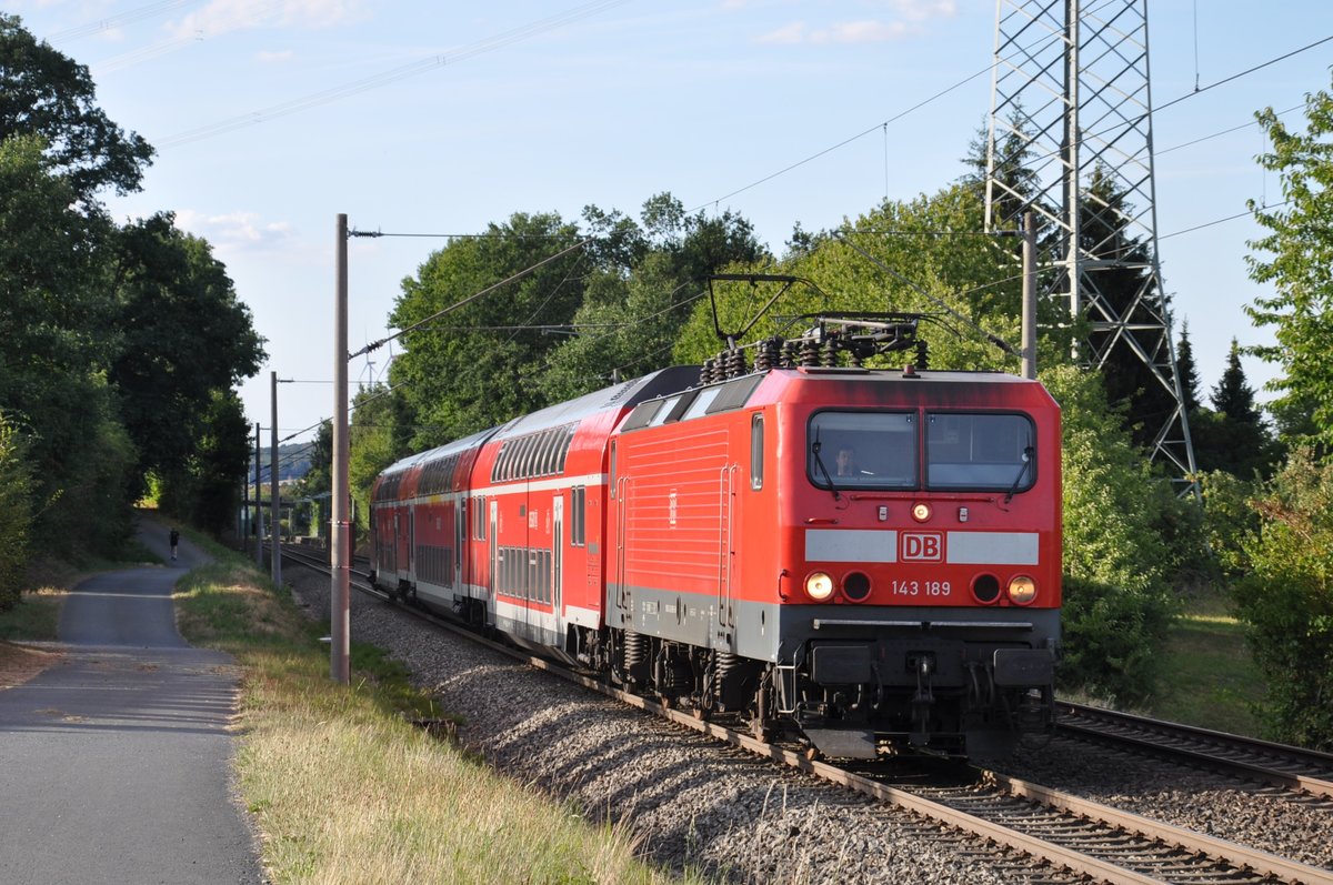 143 189 fuhr am 11.08.2018 ihre Ersatzgarnitur als RB 15277 nach Frankfurt (Main) Hbf, hier bei Wörsdorf. Der Ersatzzug bestand aus einem Fahrradwagen, einem gemischtklassigen Doppelstockwagen sowie einem modernisierten Steuerwagen der 3. Generation.
Vielen Dank an den Lokführer für den Lichtgruß! 