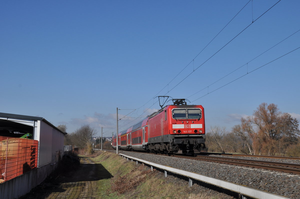 143 227 war am frühen Vormittag des 27. Februar 2021 auf dem Weg als RB22 von Limburg(Lahn) nach Frankfurt Hbf und wurde dabei unmittelbar vor dem BÜ in Ennerich fotografiert. 