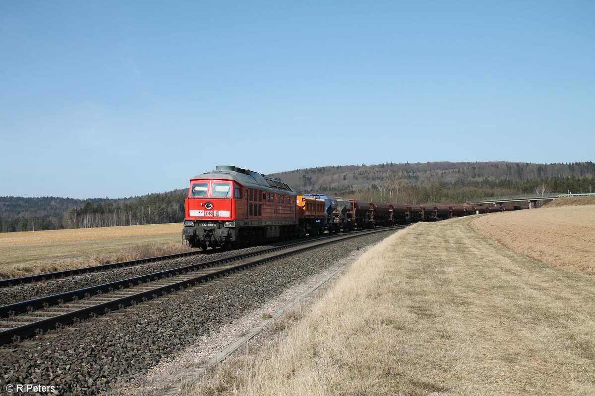 232 668 mit dem GAG 68302 Hof - Plattling leer Schotterzug bei Oberteich gen Süden. 21.03.22