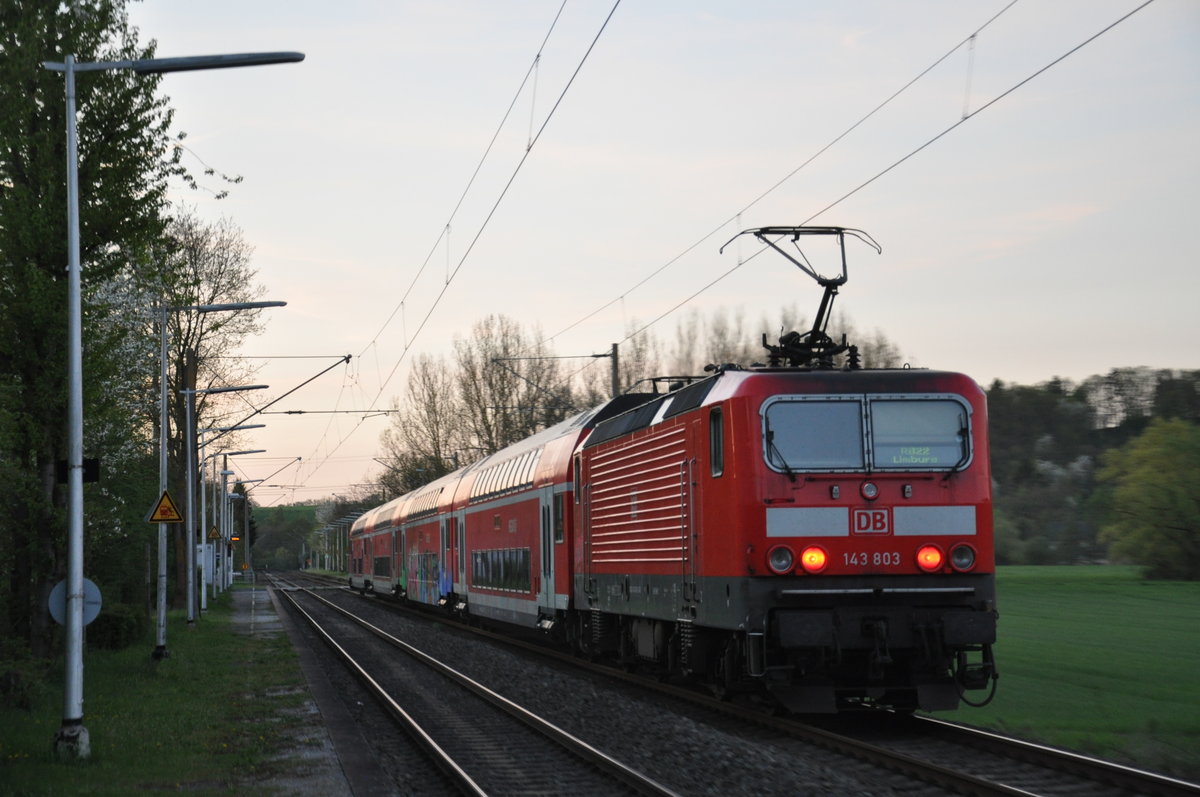 Am 19.04.2018 fotografierte ich 143 803, als sie in der Abenddämmerung mit ihrer RB22 den Haltepunkt Lindenholzhausen erreicht.