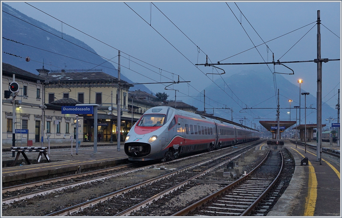 An einem noch dämmrigen Januar Morgen wartet ein FS Trenitalia ETR 610 in Domodossola auf die Weiterfahrt nach Milano. 
Der Zug verkehrt als EC 35 von Genève nach Milano Centrale.

16. Jan. 2018