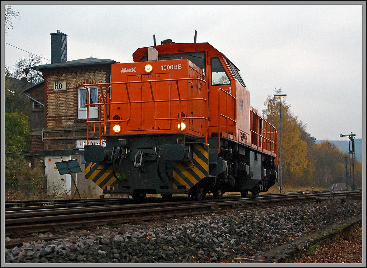 An einem trben November Nachmittag.....

Die Lok 44 - MaK G 1000 BB (271 004-4) der Kreisbahn Siegen-Wittgenstein (KSW) kommt am 18.11.2013 solo von Betzdorf und passiert hier das Stellwerk Herdorf Ost (Ho), bevor es dann auf den Rangierbahnhof der KSW geht.
 
Die Lok wurde 2003 bei Vossloh unter der Fabriknummer 1001462 gebaut und am 05.01.2004 an die KSW ausgeliefert. Sie hat die NVR-Nummer  92 80 1271 004-4 D-KSW und EBA 02G23K 004.