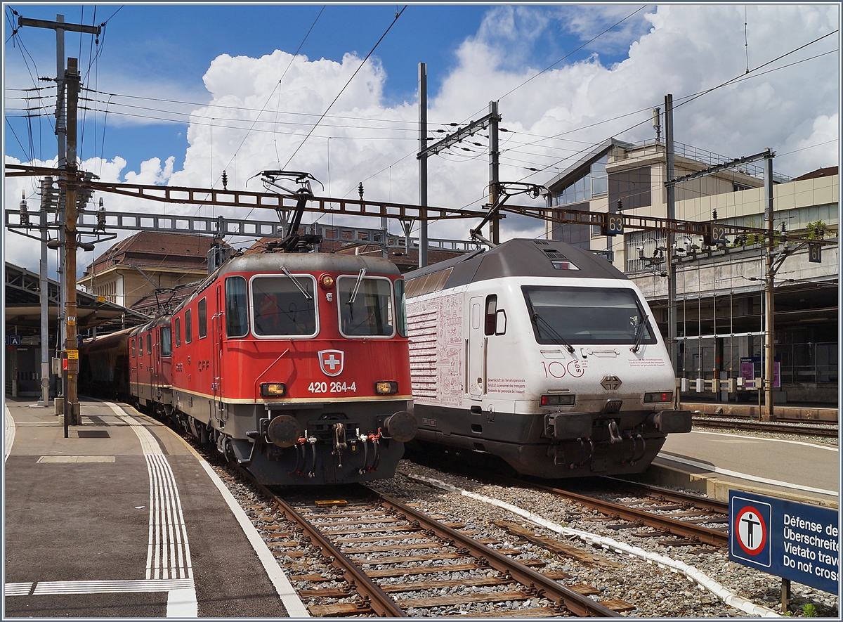 An der Lok und deren Anschriften vorbeigeschlendert und gerechnet: die 1975 gebaute Re 4/4 II 11264 ist ja schon 45 Jahre alt... Die beiden Re 4/4 II 11264 und 11296 warten in Lausanne die Blockdistanz zum IR 90 ab, um ihre Fahrt nach Domo II fortsetzen zu können. 

Rechts im Bild ist die SBB Re 460 113  100 Jahren SEV  die mit ihrem IR15 Luzern Genève - Lausanne verlässt. 

18. Juni 2020