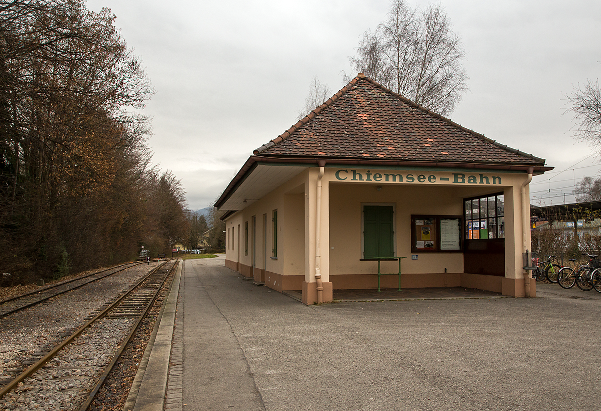 
Bahnhof der meterspurigen Chiemsee-Bahn in Prien am Chiemsee am 28.12.2016. Der Schmalspurbahnhof liegt direkt neben dem Normalspur Bahnhof der DB. 

Die Königlich Bayerischen Staats-Eisenbahnen brachten die Besucher aus München, Rosenheim und Salzburg nach Prien. Der knapp zwei Kilometer entfernte Hafen konnte vom Bahnhof Prien mit einem von der örtlichen Bevölkerung organisierten Fahrdienst erreicht werden, dieser bestand aus Kutschen und Karren. In der dörflichen Enge entstand dadurch ein erhebliches Verkehrschaos, diese Zustände kannte man zuvor nur aus der „großen Stadt“.

Bereits kurz nach dem ersten großen Ansturm auf Herrenchiemsee beantragten der Schifffahrtbetreiber Ludwig Feßler sowie der Kommerzienrat Georg Krauß aus München (Gründer der Lokomotivfabrik Krauß & Comp.) noch 1886 den Bau einer schmalspurigen Lokalbahn vom Bahnhof Prien zum Dampfersteg in Stock. Planung und Ausführung erfolgten mit einem für die damalige Zeit bemerkenswerten Tempo. Die Bauarbeiten begannen am 2. Mai 1887, schon am 21. Juni waren die Schwellen verlegt und man begann mit dem Aufnageln der Schienen. Die feierliche Eröffnung der Bahn fand nach weniger als 70 Tagen Bauzeit am 9. Juli 1887 statt. Bereits am nächsten Tag, einem Sonntag, nahm sie den offiziellen Betrieb auf.

Lieder fährt die Bahn heute nur noch in den Sommermonaten, ca. Mitte Mai bis Mitte September.