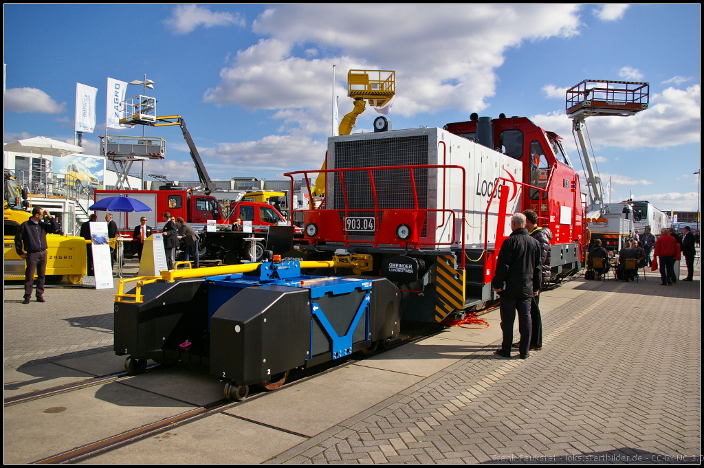 Bei dem kleinen blauen Fahrzeug vorne handelt es sich um ein elektrisch angetriebenes (Batterie) Rangierger�t der Firma Zagro. Der Rangierer verf�gt �ber ein stufenlos regelbaren Antrieb, 2 umschaltbare Geschwindigkeiten, Wenden auf der Stelle durch Allradantrieb, Rangieren in beide Fahrtrichtungen. Den Rangierer gibt es in verschiedenen Ausf�hrungen f�r verschiedenste Leistungen und Aufgaben. Ausgestellt war das Fahrzeug auf der InnoTrans 2014 in Berlin

Webseite (deutsch): http://www.zagro.de/index.php?page=rangierer_bis_700_tonnen
