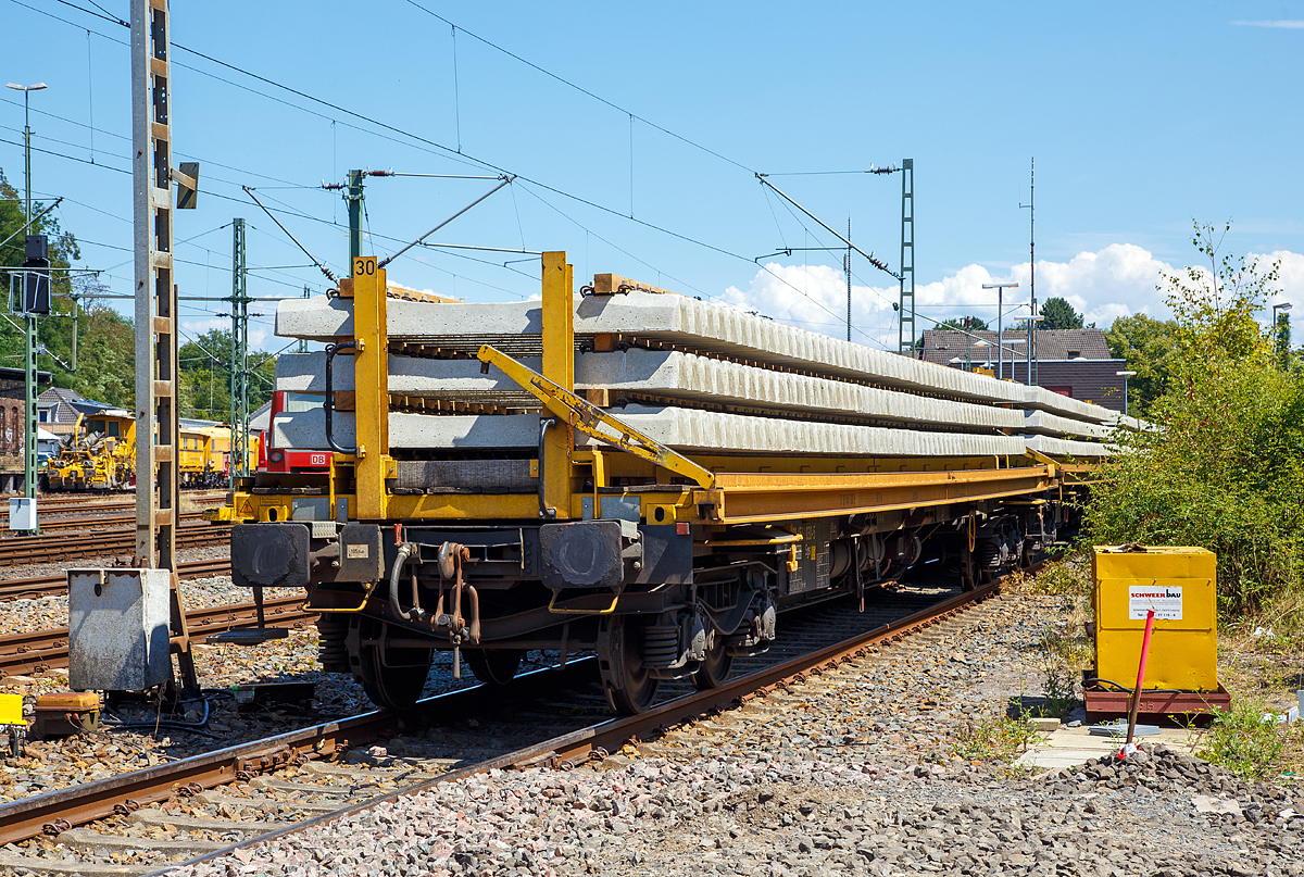 
Beladener Schwellenwagen der Schweerbau abgestellt am 15.07.2018 im Bahnhof Au (Sieg). Der Schwellenwagen besteht aus einem Drehgestell-Containertragwagen der Gattung Sgs (37 80 4541 030-5 D-WSG) und einem 8,7 t schweren Traggestell (Schwellenträger-Modul). Zwischen den einzelnen Wagen können im Baubetrieb Überfahrbrücken, für die Schwellen-Portalkrane vom Umbauzug, eingelegt werden. So können dann die Portalkrane über den ganzen Schwellenzug fahren, um Schellen zu entnehmen bzw. Alt-Schwellen wieder anzulegen, siehe http://hellertal.startbilder.de/bild/Deutschland~Unternehmen~Schweerbau/184517/schweizer-hightech-auf-der-kbs-445.html

Der Wagen ist eingestellt durch Waggonservice WSG mbH.

Technische Daten:
Spurweite: 1.435 mm
Länge über Puffer: 19.640 mm
Länge der Ladefläche: 18.400 mm
Drehzapfenabstand: 14.600 mm
Radsatzstand in den Drehgestellen: 1.800 mm
Raddurchmesser: 920 mm (neu) / 860 mm (abgenutzt)
Eigengewicht (Wagen): 18.500 kg
Gewicht des Ladegestells: 8.670 kg
Maximales Ladegewicht: 62,3 t (ab Streckenklasse C)
Max. Geschwindigkeit: 100 km/h (leer 120 km/h)
kleinster befahrbarer Gleisbogenradius: R 75 m (bei eingelegten Überfahrbrücken R 190 m)
Bremse: Ch-GP-A
Handbremse: Ja
