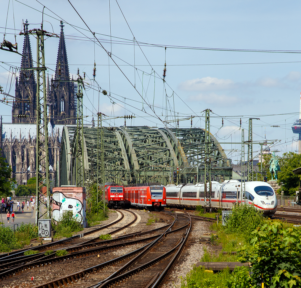 
Blick vom Bahnhof Köln Messe/Deutz am 01.06.2019 auf die Hohenzollernbrücke, dahinter folgt sofort der Hauptbahnhof Köln mit der weltweit größten Bahnhofskapelle, dem Kölner Dom.

Von der Hohenzollernbrücke kommen gerade (von links nach rechts) die DB 146 274-6 mit dem RE 5 “Rhein-Express“  und der ET 425 098-1 als RE 8 “Rhein-Erft-Express“, sowie NS (Nederlandse Spoorwegen) ICE 3M Tz 4653  erreicht bald den  Hbf.