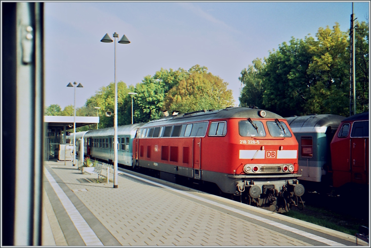 Damals noch überall anzutreffen: die DB 218; hier aus dem Fenster des  Kleber Express bei Halt in Memmingen fotografiert: die DB 218 22-5 in frischem  Neurot .

Analogbild vom 11. Oktober 2001