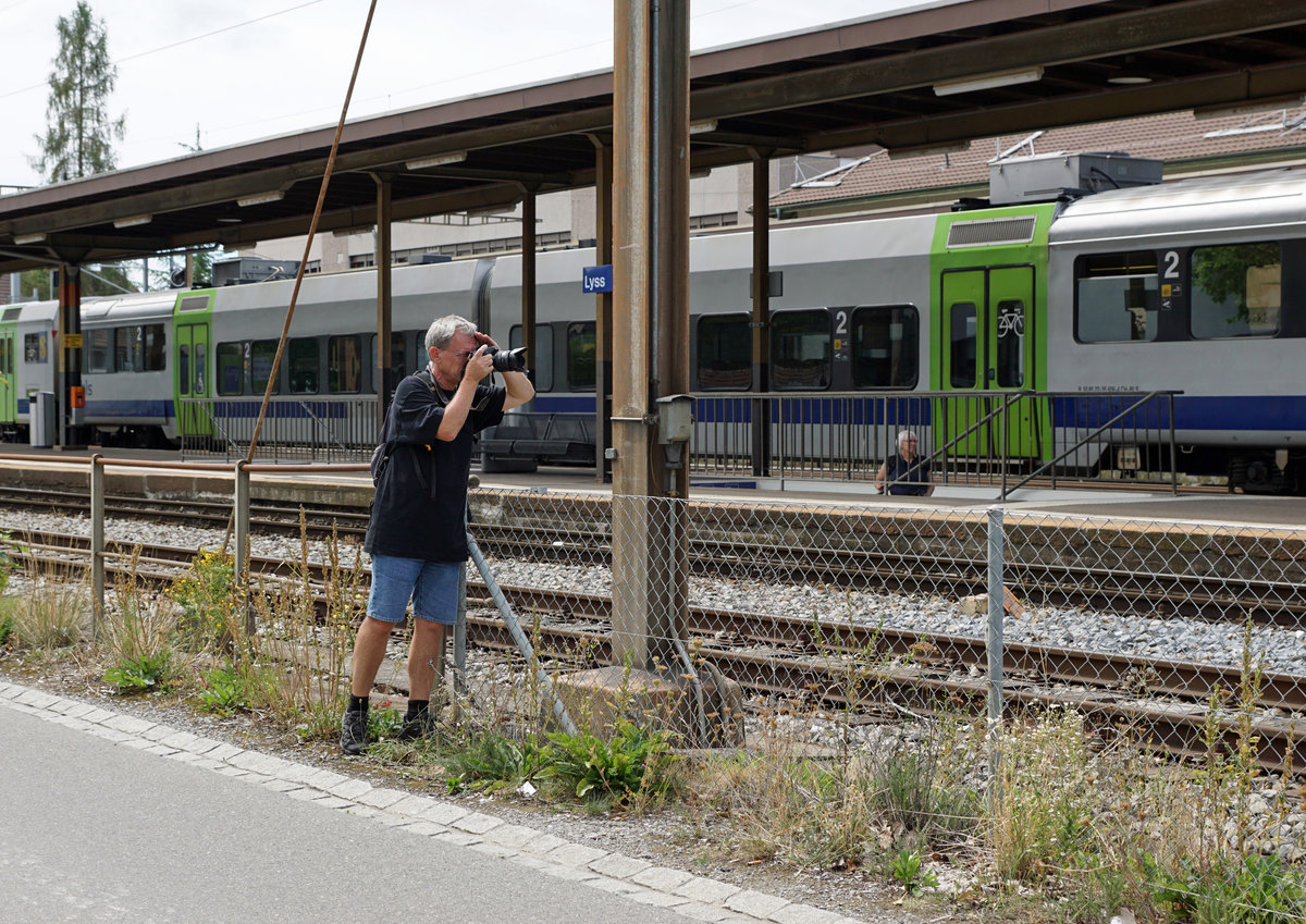 Dampftage 2018 von Lyss
Mein Lieblingsbild der besonderen Art.
Hallo Armin
Auch das gehört zum Fotografieren von Bahnen.
Kaum in Lyss angekommen, konnte ich per Zufall zu meiner grossen Freude unseren lieben Freund Stefan Wohlfahrt aus Blonay in  action  fotografieren.
Bin nicht ganz sicher, glaube aber, dass er die  Französin  im Visier hatte.
Im Hintergrund erkennbar ist seine liebe Frau Christine. 
Lieber Gruss
Walter Ruetsch
