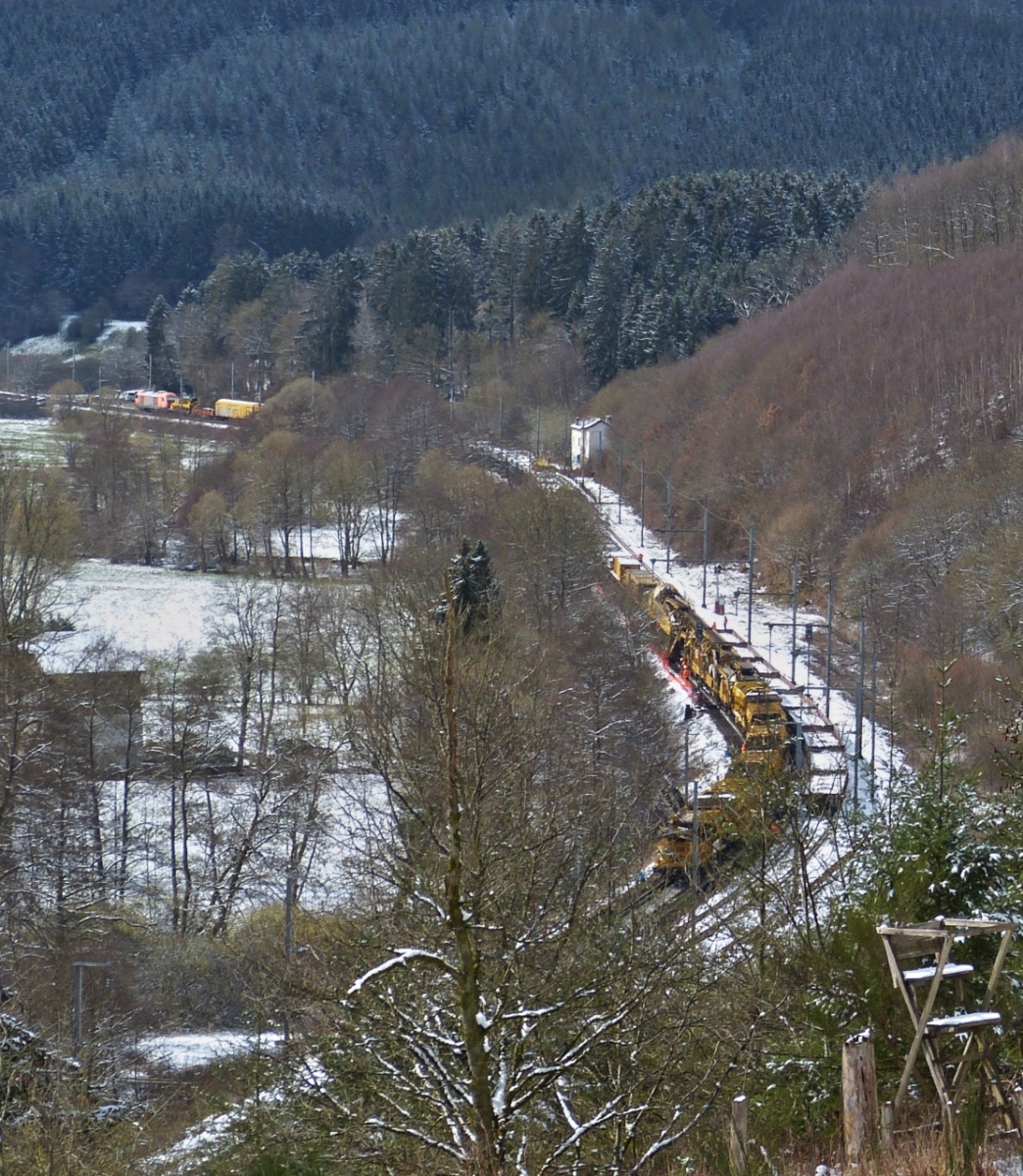 Den versuch die Lnge des Gleisumbauzuges in einem Bild festzuhalten kann ich vergessen,  Whrend Lok 2016 906 mit 6 vollbeladenen Siloschotterwagen an Mecher in Richtung Clervaux zum entladen unterwegs ist, zieht Lok 2016 905 den Gleisumbauzug imSchneckentempo ber die Gleisbaustelle beim Kaaspelterhof in Richtung Drauffelt. Bild aufgenommen von der Strae Mecher – Weicherdange ber dem Tunnel. 06.04.2021

