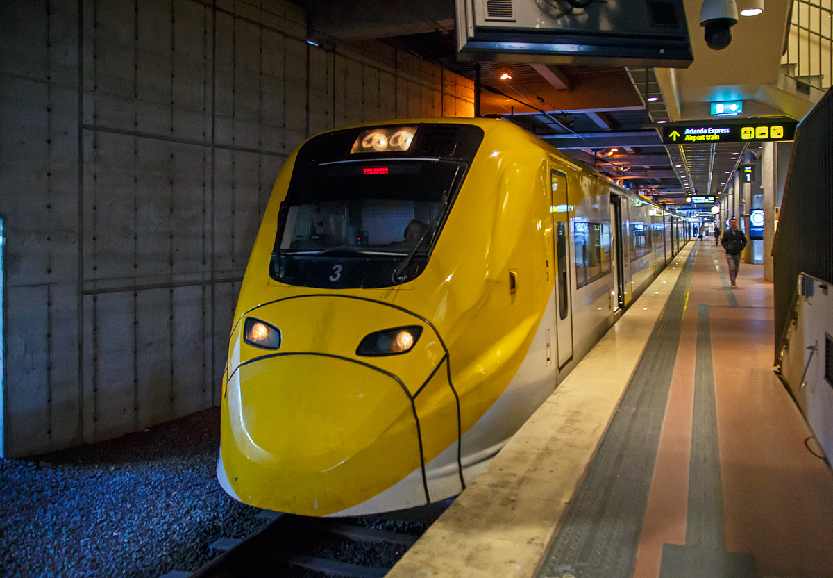 Der Arlanda Express Triebzug Nr. 3, ein Alstom Coradia X3, steht am 22.03.2019 auf Gleis 1 in Stockholm Central zur Abfahrt nach dem Flughafen Stockholm/Arlanda bereit.

Der vierteilige, normalspurige elektrische Triebwagenzug vom Typ X3 wird von der schwedischen Gesellschaft Arlanda Express fr den direkten Verkehr zwischen Stockholm C und Flughafen Stockholm/Arlanda verwendet.

Von Alstom wurden sieben dieser klimatisierten Zge in Birmingham gebaut und 1998/99 geliefert. Der X3 gehrt zur Obergruppe der Coradia-Triebwagen und kann Geschwindigkeiten bis 205 km/h erreichen. Die Zge sind wei und gelb lackiert. Die Triebwagen nutzen das gleiche Stromsystem, wie es im gesamten schwedischen Eisenbahnnetz vorhanden ist.

TECHNISCHE DATEN:
Spurweite:  1435 mm (Normalspur)
Achsformel: Bo'Bo'+2'2'+'2'2+Bo'Bo'
Lnge ber Kupplung: 93.084 mm
Dienstgewicht: 187 t
Hchstgeschwindigkeit: 200 km/h
Leistung: 2.240 kW
Stromsystem: 15 kV 16,7 Hz ~
Sitzpltze:  228

Arlanda Express ist eine schwedische Bahnverbindung, die mit dem 200 km/h schnellen Elektrotriebzug X3 seit 1999 den Stockholmer Hauptbahnhof mit dem Flughafen Stockholm/Arlanda verbindet. Die Zge bewltigen die Strecke in 20 Minuten. Am Flughafen bedienen sie die Stationen Arlanda Sdra und Arlanda Norra. Die Zge verkehren bis auf wenige Ausnahmen in den Tagesrandzeiten alle 15 Minuten, im Berufsverkehr etwa alle zehn Minuten.

In Arlanda und im Hauptbahnhof von Stockholm am Gleis 1 und 2 haben die Zge gesonderte Bahnsteige. Dort ist ein direkter stufenloser bergang vom Zug zum Bahnsteig mglich. Jeder Wagen verfgt ber zwei Tren und an jeder Tr sind Gepckablagen vorhanden. Der gesamte Zug besitzt 190 Sitzpltze. In einem der Wagen sind gesonderte Pltze fr Rollstuhlfahrer sowie ein WC vorhanden.