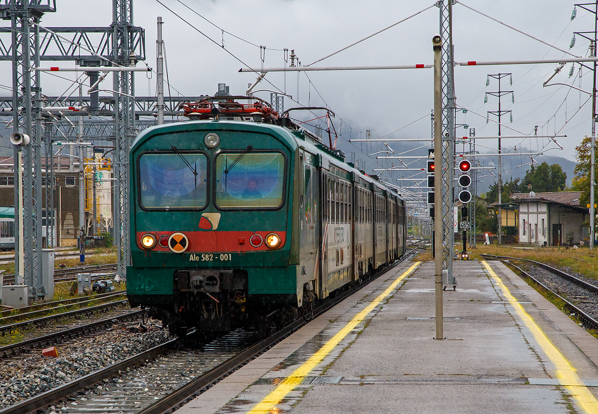 Der dreiteilige Ale 582-001 (ALe.582 001 /Le.763 1xx /Le.562 0xx) der Trenord erreicht am 03.11.2019 als Regionalzug bei Regen, den Bahnhof Lecco (italienisch: Stazione di Lecco). 

Diese Elektrische Triebzüge wurden nach dem Vorbild der ALe 724 zwischen 1987 und 1991 gebaut.

TECHNISCHE DATEN:
Triebwagen ALe 582
Nummerierung: ALe 582 001-090
Gebaute Einheiten: 90
Baujahre: 1987 - 1989
Hersteller: Breda Pt - Marelli, Fiore - Ansaldo, Fiore – Lucana
Spurweite: 1.435 mm (Normalspur)
Achsfolge: Bo 'Bo'
Länge über Puffer: 26.115 mm
Drehzapfenabstand: 18.640 mm
Achsabstand im Drehgestell: 2.560 mm
Raddurchmesser: 860 mm
Eigengewicht: 54 t
Anzahl der Motoren: 4
Motortyp: 4 EXH 4046
Übersetzungsverhältnis: 30/75
Stundenleistung: 4 x 315 kW = 1.260 kW
Dauerleistung: 4 x 280 kW = 1.120 kW
Höchstgeschwindigkeit: 140 km/h
Stromsystem: 3 kV DC
Sitzplätze: 17 (1.Klasse) - 41 (2. Klasse)

Mittelwagen Le 763
Nummerierung: Le 763.101 – 163
Gebaute Einheiten: 163
Baujahre: 1987 – 1991
Hersteller: Fiore, Stanga
Achsfolge: 2' 2'
Länge über Puffer: 25.780 mm
Drehzapfenabstand: 18.640 mm
Achsabstand im Drehgestell: 2.560 mm
Raddurchmesser: 860 mm
Eigengewicht: 30 t
Höchstgeschwindigkeit: 140 km/h
Sitzplätze: 76 in der 2.Klasse

Steuerwagen Le 562
Nummerierung: Le 562.001 - 068
Gebaute Einheiten: 68
Baujahre: 1987 – 1989
Hersteller: OMS - Ansaldo, Fiore - Ansaldo
Achsfolge: 2' 2'
Länge über Puffer: 26.115 mm
Drehzapfenabstand: 18.640 mm
Achsabstand im Drehgestell: 2.560 mm
Raddurchmesser: 860 mm
Eigengewicht: 30 t
Höchstgeschwindigkeit: 140 km/h
Sitzplätze: 56 in der 2.Klasse 