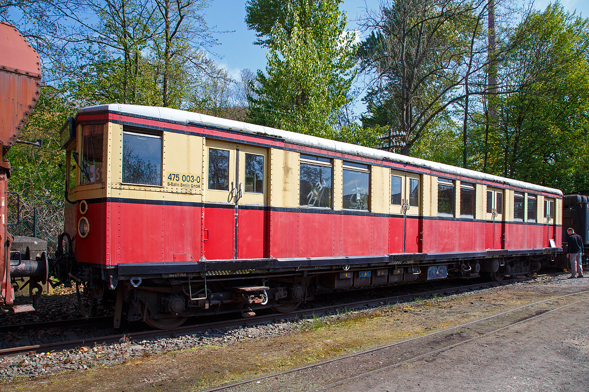 
Der ehemalige Berliner S-Bahn Triebwagen 475 003-0, ex DR 275 031-3, am 30.04.2017 im Eisenbahnmuseum Bochum-Dahlhausen.

Der Triebwagen wurde 1928 von Orenstein & Koppel (O & K) in Berlin gebaut und als elT 2228 an die Deutsche Reichsbahn-Gesellschaft (DRG) geliefert.
Der Wagen hat die folgenden Fahrzeugnummern getragen:
1928 bis 1930 DRG elT 2228
1930 bis 1941 DRG (ab 1937 DR) elT 3150
1941  bis 1970 DR ET 165 080 
1970 bis 1991 DR 275 031-3 
1992 bis 1993 DR 475 003-0 und 
1994 bis zur Ausmusterung 1997 DB 475 003-0.

Der ET 165, später Baureihe 275 (DR) bzw. 475 (DB AG), ist ein elektrischer Triebwagen, der für den Verkehr im Gleichstrom-Netz der Berliner S-Bahn von 1928 bis 1932 gebaut wurde. Die Züge waren noch bis 1997 im Berliner S-Bahn-Netz unterwegs, wurden aber bis Mai 2004 mit Ausnahme einiger Museumsstücke verschrottet.

Die Baureihe ET 165 wurde ab 1928 bis 1932 gebaut. Es handelt sich hierbei um knapp 36 Meter lange sogenannte Viertelzüge, die aus je einem elektrischen Triebwagen und einem antriebslosen Steuerwagen bestanden. Sie ist der hier gezeigte Triebwagen eigentlich nur ein Achtelzug.
Bis zu vier dieser Viertelzüge konnten zu einem rund 145 Meter langen Vollzug gekuppelt eingesetzt werden, der eine in der Praxis nutzbare Platzkapazität von ungefähr 1000 Sitz- und Stehplätzen und ein für damalige Verhältnisse hervorragendes Beschleunigungs- und Bremsvermögen aufwies. Mit dieser Fahrzeugkonzeption konnten die damaligen Anforderungen des Berliner S-Bahn-Verkehrs voll erfüllt werden.

Die Konstruktion basiert auf der DR-Baureihe ET 168 (Bauart Oranienburg) aus dem Jahr 1925. Oberstes Ziel war hierbei die Herabsetzung des Leergewichtes, da die Oranienburger mit etwa 45 Tonnen für den Trieb- und 36 Tonnen für den Steuerwagen für den Stadtbahnbetrieb mit häufigem Halten und Wiederanfahren viel zu schwer ausgefallen war. Man konnte die diese neuen Fahrzeuge durch den Einsatz wesentlich dünnerer, aber aus hochfestem Silizium-Stahl hergestellter Profile um ca. 18 % leichter ausführen (etwa 38 Tonnen beim ET und 27 Tonnen beim ES), außerdem ließen sich zum ersten Mal die Türen vom Führerstand aus schließen. Mit diesen Wagen begann der großflächige Ausbau des elektrifizierten Stadtbahnnetzes in Berlin. Die Fahrzeuge wurden nach einheitlichen Plänen von vielen namhaften Waggonbaufirmen gebaut und in dem eigens für die neuen S-Bahn-Triebwagen damals neu erbauten Reichsbahnausbesserungswerk Schöneweide elektrisch ausgerüstet. Am 11. Juni 1928 fuhr zum ersten Mal diese Baureihe auf der neu elektrifizierten Strecke von Potsdam über die Stadtbahn nach Erkner. Dementsprechend auch als Bauart Stadtbahn bezeichnet, wurde die Baureihe zu einer Legende. Bis Ende 1933 entstanden insgesamt 1276 Einzelwagen, die meist gebaute Triebwagenserie der deutschen Eisenbahngeschichte.

Im Jahr 1932 erfolgte anlässlich der Elektrifizierung der Wannseebahn die Lieferung des letzten Bauloses mit 51 Viertelzügen. Diese Baureihe ET 165.8 erhielt den Namen Bauart Wannseebahn. Sie entsprach bis auf ein geändertes Schaltwerk (jetzt rein elektrisch angetrieben) und einen Wagenkasten ohne sichtbare Nietreihen (Senknietung in Verbindung mit Punktschweißung dünnerer Verkleidungsbleche) der Stammbaureihe ET 165.

Charakteristisch für den Ursprungszustand dieser Baureihe war die Frontansicht mit einem weißen Spitzensignal (Scheinwerfer) in der Mitte und dem beleuchteten Schilderkasten sowie den zwei roten Oberwagenlaternen als Schlusssignal. Die klassische Frontansicht dieser Baureihe blieb bei den meisten Zügen bis Ende der 1960er Jahre erhalten. Die Nachfolgebaureihen ab 1934 (ET 125, ET 166 und ET 167) hatten bereits zwei große Frontscheinwerfer, die entweder ein Zwei-Licht-Spitzensignal oder ein Zwei-Licht-Schlusssignal zeigen konnten.

Von 1965 bis 1969 (und in einer zweiten Serie 1979) wurde ein großer Teil der Stadtbahnwagen auf Einmannbetrieb (EMB) umgebaut. Die Führerstände erhielten Bordfunkgeräte, mit denen der Abfahrauftrag der Aufsichten von den Bahnsteigen übermittelt werden konnte. Der bislang noch notwendige Schaffner, der während der Abfahrt an der Tür stand und den Zug und die Bahnsteigaufsicht zu beobachten hatte, konnte entfallen. Beim Umbau wurden die vorher sehr beengten Führerstände vergrößert. Hierbei mussten im Fahrgastraum vier Sitzplätze an der Führerstandsrückwand entfallen, um diese nach hinten versetzen zu können. Äußerlich waren die Einmannzüge (EMB-Viertel) an den je zwei Spitzen- und Schlusslampen mit Alurahmen der Standardbauart (z. B. E 11 und E 42) in den Stirnwänden und der Antenne für die Abfertigung per Funk zu erkennen.

TECHNISCHE DATEN:

Gebaute Stückzahlen:  638 Triebwagen, 465 Steuerwagen und 173 Beiwagen
Hersteller:  AEG, DWF, O&K, SSW, WUMAG
Baujahre:  1928–1931
Ausmusterung:  1997
Spurweite:  1.435 mm (Normalspur)
Achsformel:  Bo'Bo'
Breite:  3.000 mm
Drehzapfenabstand:  11.800 mm
Drehgestellachsstand: 2.500 mm
Leergewicht:  38,4 t
Höchstgeschwindigkeit:  80 km/h
Stundenleistung:  360 kW
Beschleunigung:  0,3 und 0,5 m/s² je nach Fahrschalterstellung
Raddurchmesser:  900 mm
Stromsystem:  750 V =
Stromübertragung:  seitliche, von unten bestrichene Stromschiene
Anzahl der Fahrmotoren:  4
Zugheizung:  elektrisch
Geschwindigkeitsmesser:  DEUTA
Kupplungstyp:  Scharfenbergkupplung
Fußbodenhöhe:  1.100 mm