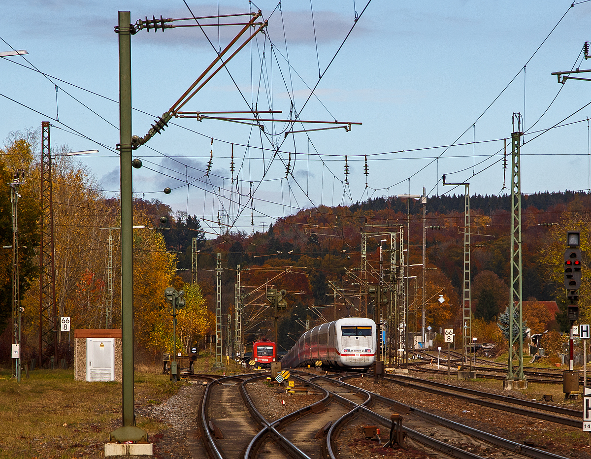 Der ICE 1 – Tz 163, geführt von dem Triebkopf 401 063-3 und am Zugschluss 401 563, fährt am 26.10.2021 von  Amstetten (Württ) nun die berühmte Geislinger Steige hinab. Am ICE sieht man auch nun gut den Gefälleknick.

Und links kommt in Gegenrichtung nun die ÖBB 1116 041 „Carmem & Christian“ mit einem Güterzug die Steige hinauf. Sie bekommt auf der Geislinger Steige Schubhilfe von einer DB 185er.
