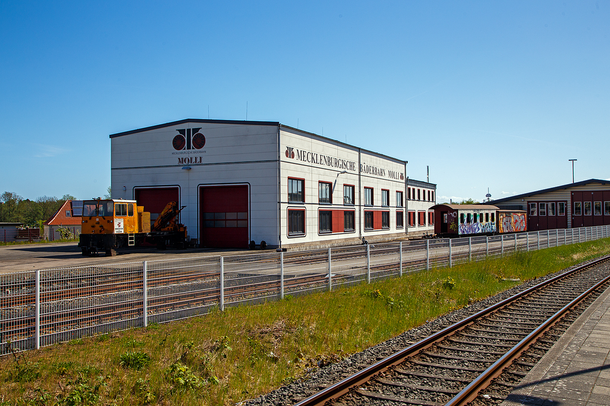 Der Lokschuppen/Werkstatt der Mecklenburgische Bäderbahn Molli GmbH „Molli“ in Bad Doberan, hier am 15.05.2022. Davor aufgebockt ohne Achsen steht das Mehrzweckarbeitsfahrzeug Rolba Railway RR 2/200 (Baureihe MBW-A-02) der Florianer Bahn Forschungs- und Errichtungsgesellschaft m.b.H..