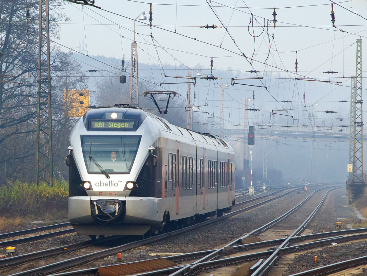 
Der morgendliche Nebel hat sich noch nicht ganz aufgelöst....
Der ET 23 2107 (94 80 0427 106-0 D-ABRN / 94 80 0827 106-6 D-ABRN / 94 80 0427 606-9 D-ABRN), ex ET 23007, ein 3-teiliger Stadler FLIRT der Abellio Rail NRW GmbH, erreicht am 05.12.2015, als RB 91  Ruhr-Sieg-Bahn  (Hagen-Siegen) nun den Bahnhof Kreuztal.