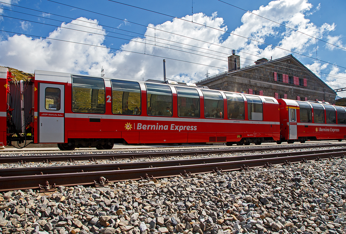 Der RhB Bps 2514 ein 4-achsiger 2.Klasse Bernina-Express Panoramawagen mit Serviceabteil der 2. Serie (Nachbau-Serie) am 06.09.2021, im Zugverband des BEX nach St. Moritz, in Ospizio Bernina.

Fr den berhmten Bernina-Express lie die Rhtische Bahn RhB 26 Panorama-Wagen in zwei Serienbauen. Gegenber den zuvor fr andere Strecken gebauten Wagen, weisen die Bernina-Wagen eine um 3,2 m geringere Gesamtlnge auf. Es entstanden neun 1.Klasse- und siebzehn 2.Klasse-Wagen, die sich groer Beliebtheit bei den Fahrgsten erfreuen.

Um den Bernina-Express einheitlich mit Panoramawagen ausrsten zu knnen, wurden 2006–2007 die 2.Serie von 16 Wagen (Api 1301–1306, Bps 2512–2515, Bp 2521–2526) als Nachbauserie beschafft. Diese erhielten nun allerdings luftgefederte Stadler-Drehgestelle und eine (vakuumgesteuerte) Druckluftbremse. Die vakuumgesteuerte Druckluftbremse wurde auch bei den bestehenden Wagen nachgerstet. Zudem wurde im Erstklasswagen eine rollstuhlgngige Toilette eingebaut. Da inzwischen das Rauchen in Schweizer Zgen generell verboten wurde, konnte auch auf eine Trennwand fr ein Raucherabteil verzichtet werden, bei den bisherigen Wagen wurde diese entfernt.

TECHNISCHE DATEN Bps-Wagen:
Baujahr: 2006/2007
Hersteller: Stadler
Spurweite: 1.000 mm
Anzahl der Achsen: 4
Lnge ber Kupplung: 16.450 mm
Breite: 2.650 mm
Hhe: 3.540 mm
Fubodenhhe: 993 mm
Drehgestellart: luftgefederte Stadler-Drehgestelle
Achsabstand im Drehgestell: 1.800 mm
Laufraddurchmesser: 685 mm (neu)
Sitzpltze: 43
Stehpltze: 49
Eigengewicht: 18 t
Nutzlast: 6,1 t
zulssige Geschwindigkeit: 100 km/h
Toilette: 1 komfortables geschlossenes WC-System
Lauffhig: StN (Stammnetz) / BB (Berniabahn) / MGB (Matterhorn Gotthard Bahn)