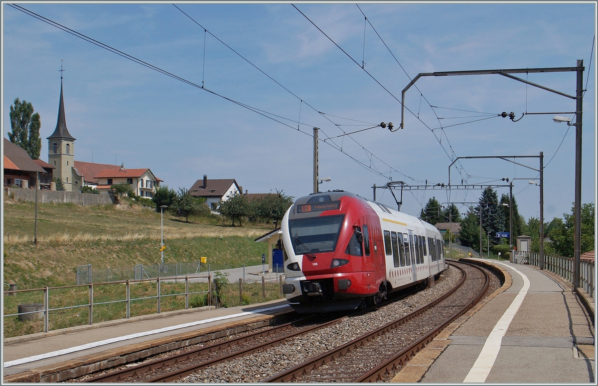 Der TPF RABe 527 195 fährt durch die Haltestelle Neyruz.
6. August 2015