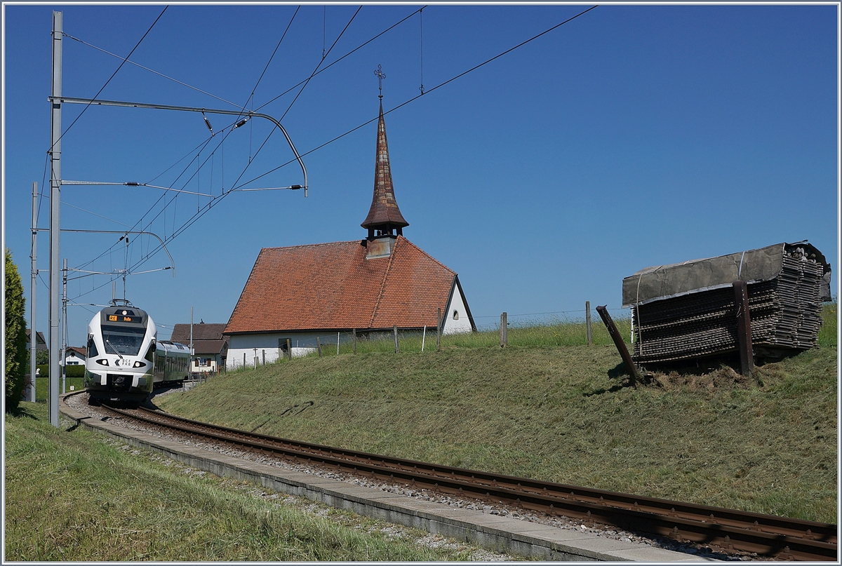 Der TPF RABe 527 198  BCF / FKB  (Kantonalbankwerbezug) erreicht Vaulruz, links im Bild die mittlerweile bekannte Kapelle von Vaulruz, rechts, die hier typischen an den Gleisböschung stehenden Bretterstapel.

19. Mai 2020 