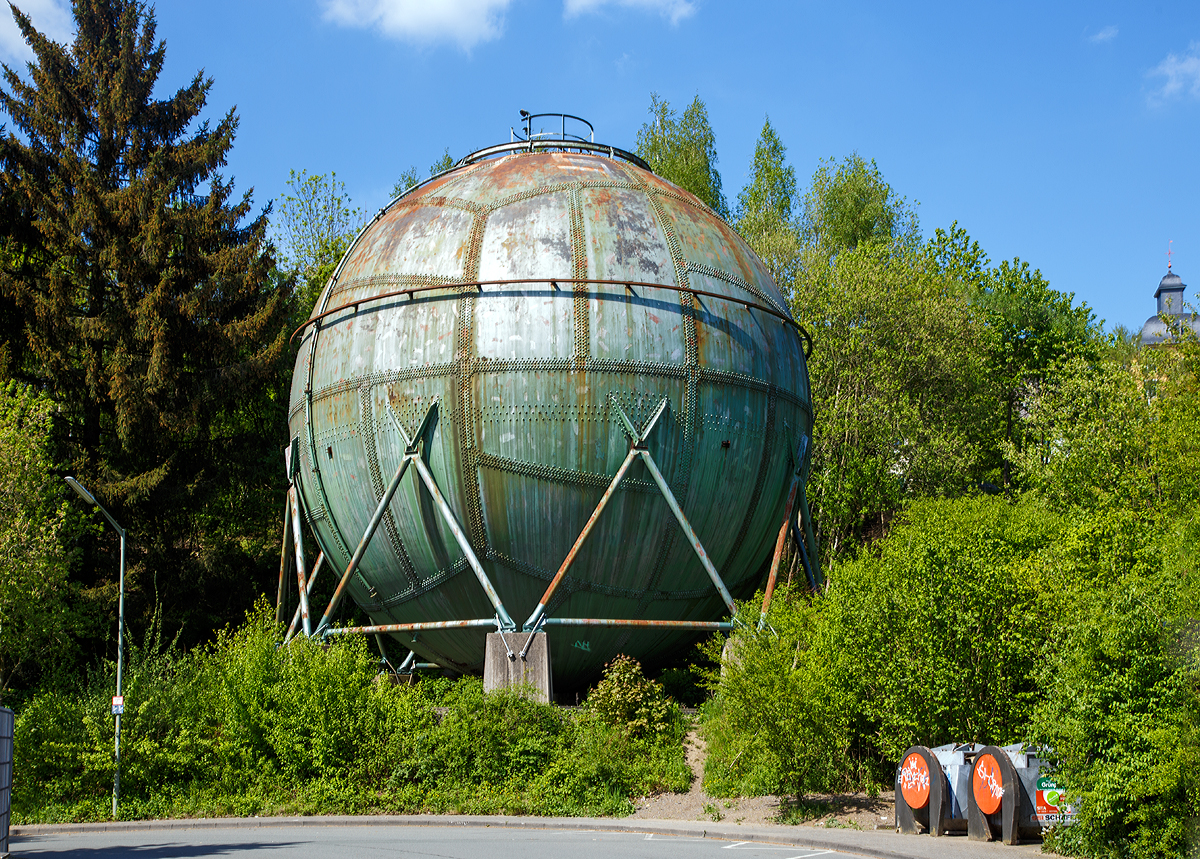 
Der unter Denkmalschutz stehende genietete Kugel-Gasbehälter in Siegen am 10.05.2015.

Der Kugelgasbehälter wurde in den Jahren 1934/35 von der Fa. Kölsch-Fölzer-Werke AG in Siegen erbaut und diente als Leuchtgas- bzw. Stadtgas-Hochdruck-Speicherbehälter mit einem Betriebsdruck von 5.1 bar. Er diente dem Ausgleich der Schwankungen zwischen Abnahme und Zulieferung des Gases. 1968 erfolgte die Umstellung auf Erdgas im Stadtnetz der Siegener Versorgungsbetriebe. Er war bis 1978 in Betrieb und war somit der letzte im Betrieb befindliche genietete Kugel-Gasbehälter in Deutschland und das ohne eine Schweißnaht. 1993 wurde der Gasometer im Zuge von Straßenbauarbeiten an den heutigen Standort, um 46 m versetzt.

Die Kugelmantelfläche wird aus 48 Blechen gebildet. Die großen Bleche wurden gewählt, um eine möglichst geringe Länge der Nietnähte zu erhalten und Gewicht zu sparen. Zudem wird die Dichtigkeit der Behälter erhöht, je weniger Nietnähte vorhanden sind.
Mit dem Einsatz von Kugelgasbehältern wurde bei der Gasspeicherung technisches Neuland beschritten. Im Allgemeinen wurden Gasbehälter als Niederdruckgasspeicher entweder als Behälter mit Wasserbassins oder als Scheibenbehälter ohne Wasserbassins ausgebildet.
Der Kugelgasbehälter verfolgt als Hochdruckgasbehälter eine andere konstruktive Lösung. Die Entwicklung und Bauausführung derartiger Kugelgasbehälter erfolgte erst ab Mitte der 1920er Jahre. 

Die Kugelform hat mehrere Vorteile. Verglichen mit allen anderen geometrischen Körpern hat die Kugel bei gleichem Volumen die kleinste Oberfläche. Der Materialaufwand ist für kugelförmige Behälter daher am kleinsten. Außerdem verteilen sich Spannungen aus der Druckdifferenz zwischen Innenraum und Umgebung gleichmäßig in der Behälterwand, was relativ geringe Wanddicken erlaubt. Thermische Einflüsse durch Sonneneinstrahlung sind wegen der nahezu gleichen Einstrahlungsfläche weniger vom Sonnenstand abhängig. Nachteilig ist die aufwendige Fertigung der mehrfach gekrümmten Behälterelemente, beispielsweise gegenüber Röhrenspeichern.