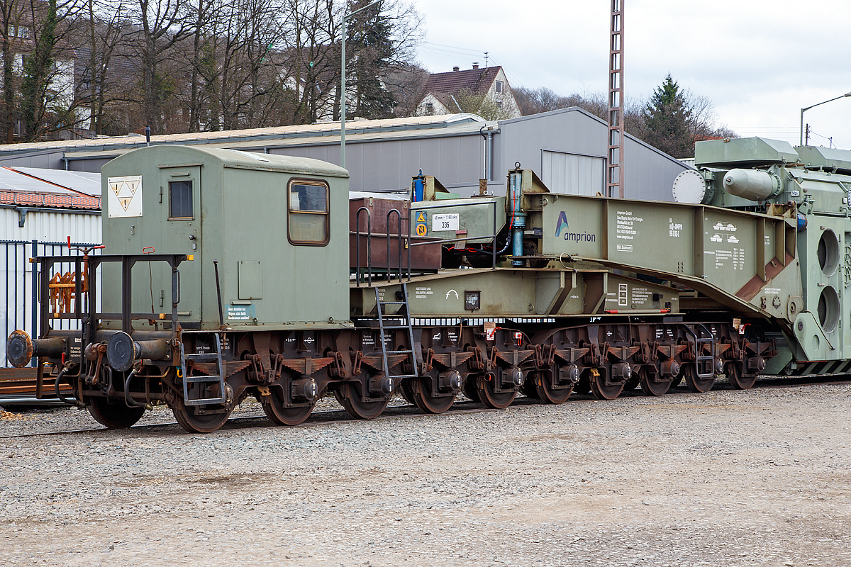 
Detailbild von dem 20-achsigen Tragschnabelwagen der Gattung Uaai 687.9 (84 80 996 0 003-5 D-AMPR) der Amprion GmbH beladen mit einem 150 000 kVA Wandertransformator (Trafo 211) der Trafo-Union (heute Siemens) abgestellt am 17.03.2017 in Kreuztal. 

Die Amprion GmbH ist ein deutscher Übertragungsnetzbetreiber für den Strombereich. Das Unternehmen, welches als Teil des RWE-Konzerns entstand, beschäftigt etwa 1100 Mitarbeiter, sein Hauptsitz befindet sich in Dortmund.

Der Tragschnabelwagen wurde 1961 bei MAN unter der Fabriknummer 146523 gebaut. Es wurden 3 Stück der Bauart Uaai 687.9 hergestellt.

TECHNISCHE DATEN:
Spurweite: 1.435 mm (Normalspur)
Anzahl der Achsen: 20 in 4 Drehgestellen á 5 Achsen
Gattung/Bauart: Uaai 687.9
Länge über Puffer: 32.070 mm (Leerfahrt) / 41.140 mm (mit Trafo)
Drehzapfenabstand 1: 15.886 mm (Leerfahrt) / 24.956 mm (mit Trafo)
Drehzapfenabstand 2 (zw. den DG1+2 / DG 3+4): 7.500 mm
Achsabstand in den Drehgestellen: 1.500 mm
Laufraddurchmesser: 1.000 mm
Eigengewicht: 117 t
Maximale Ladegewicht: 250 t
Achsdruck: 5,85 t (Leerfahrt) / 18,35 t (mit Trafo)
Meterlast: 3,65 t/m (Leerfahrt) / 8,92 t/m (mit Trafo)
Höchstgeschwindigkeit: 90 km/h (Leerfahrt) / 40 km/h (Beladen)
Kleinster befahrbarer Gleisbogenhalbmesser: 75 m
Tragende Bauteile gefertigt aus: MSt 52-3
Bauart der Handbremse: bodenbedienbare Handbremse 2 x 45 t